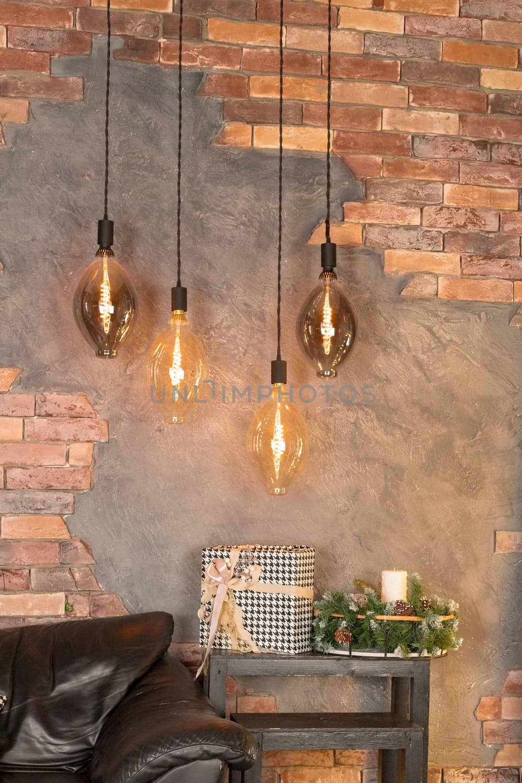 A group of four lighted lamps hanging from the ceiling. The lamps are all different sizes and shapes, but they all have a similar design. The lamps are lit up, creating a warm and inviting atmosphere