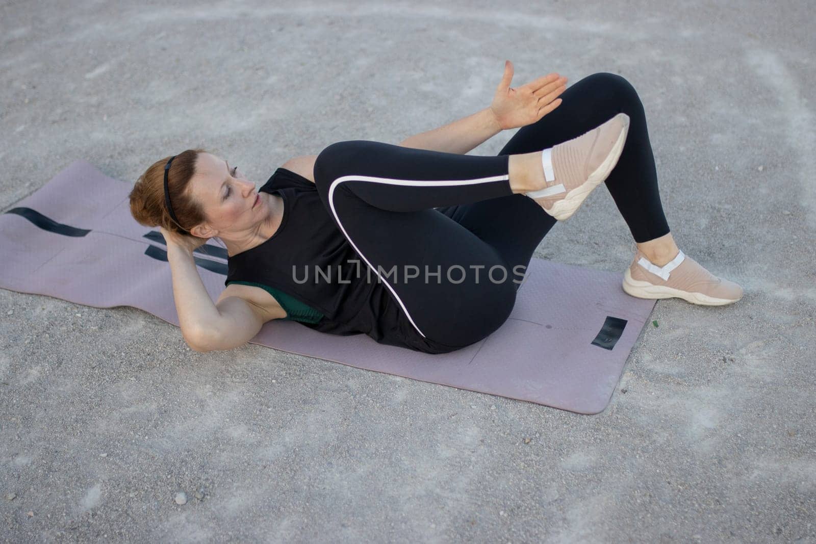 Woman is training her abdominal muscles by doing crunches on a mat
