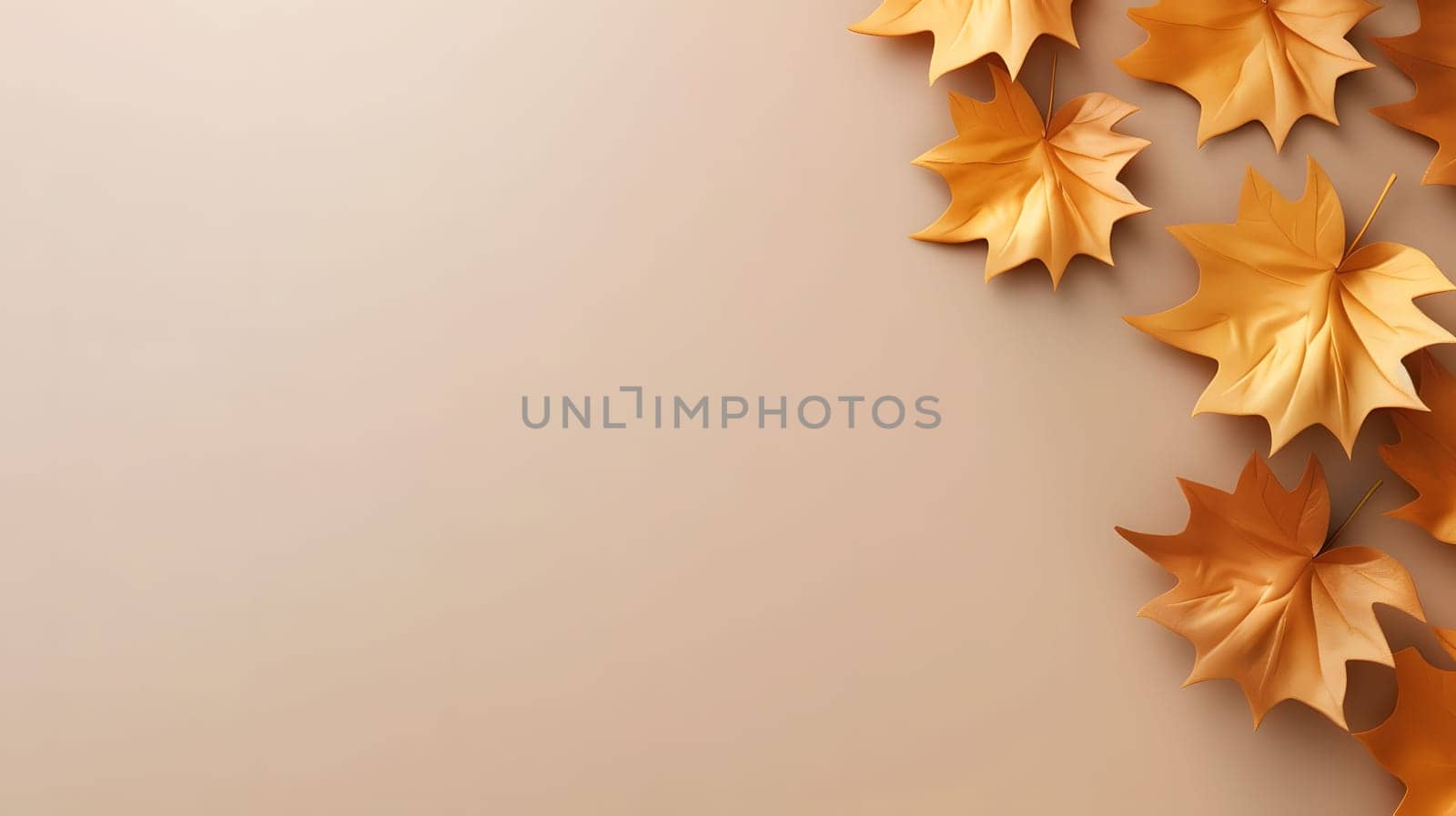 Golden fall leaves arranged on a beige background. Simple minimalist design for autumn.