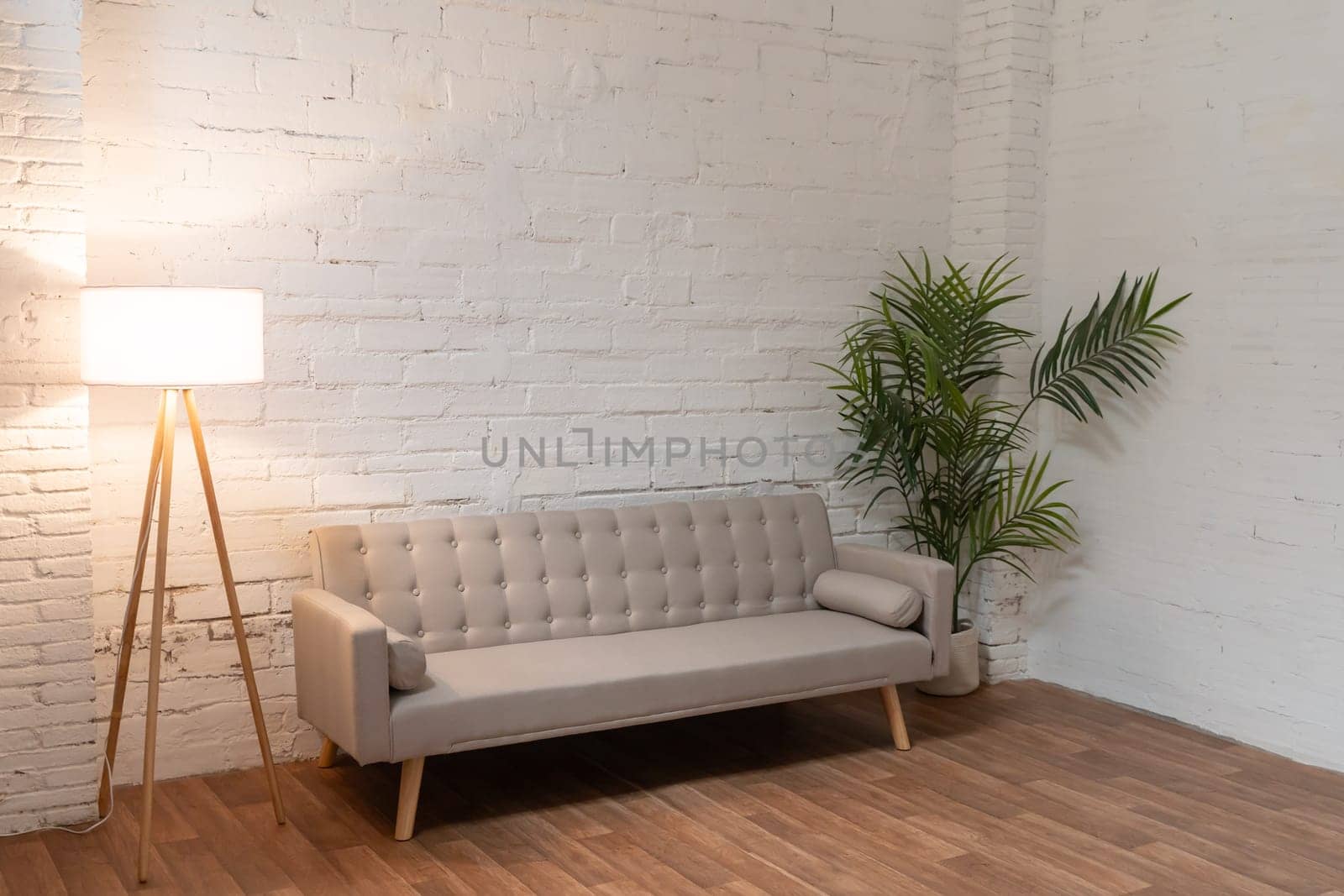 Sofa over white brick wall with copy space. High quality photo