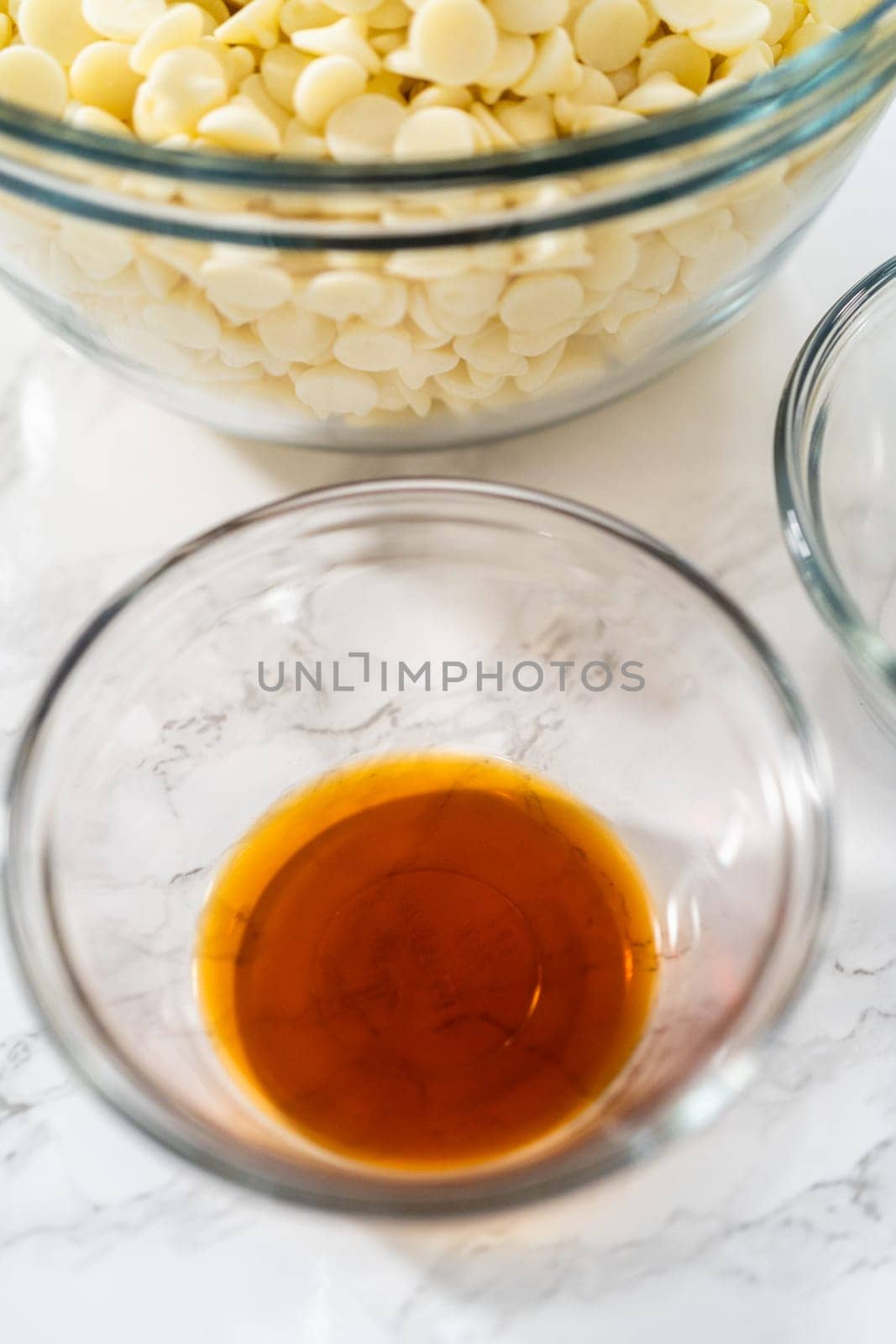 Measured ingredients in glass mixing bowls to make white chocolate ganache frosting.