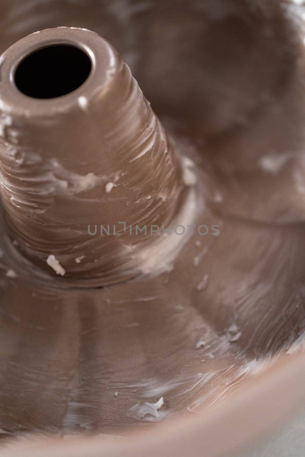 Greasing metal bundt cake pan to red velvet bundt cake with cream cheese glaze.