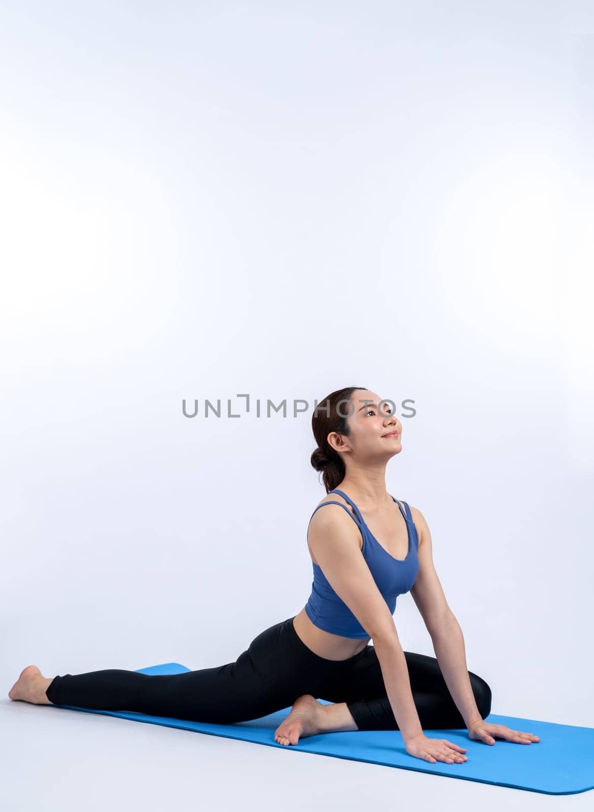 Asian woman in sportswear doing yoga exercise on fitness mat. Vigorous by biancoblue