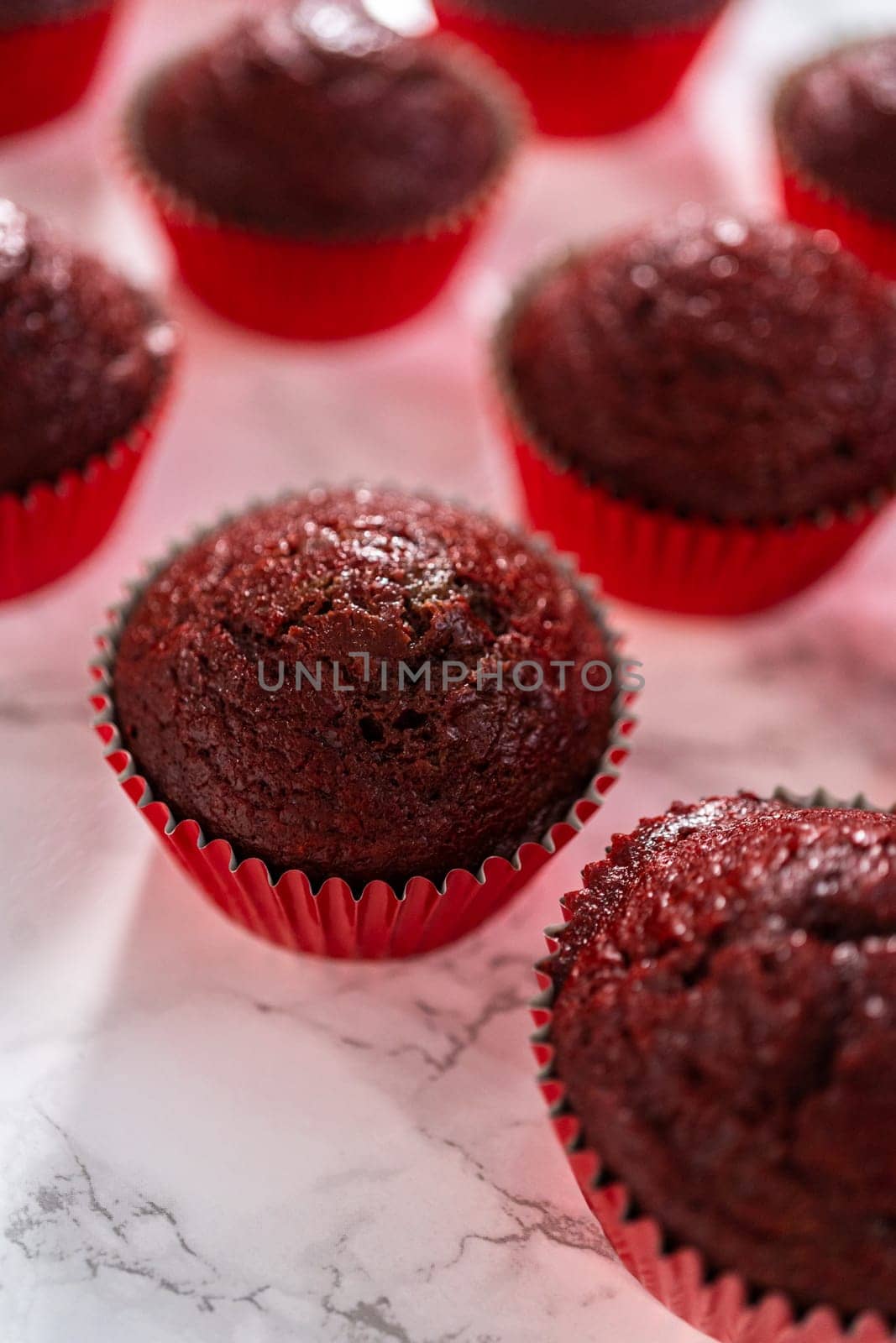 Cooling freshly baked red velvet cupcakes on a kitchen counter.