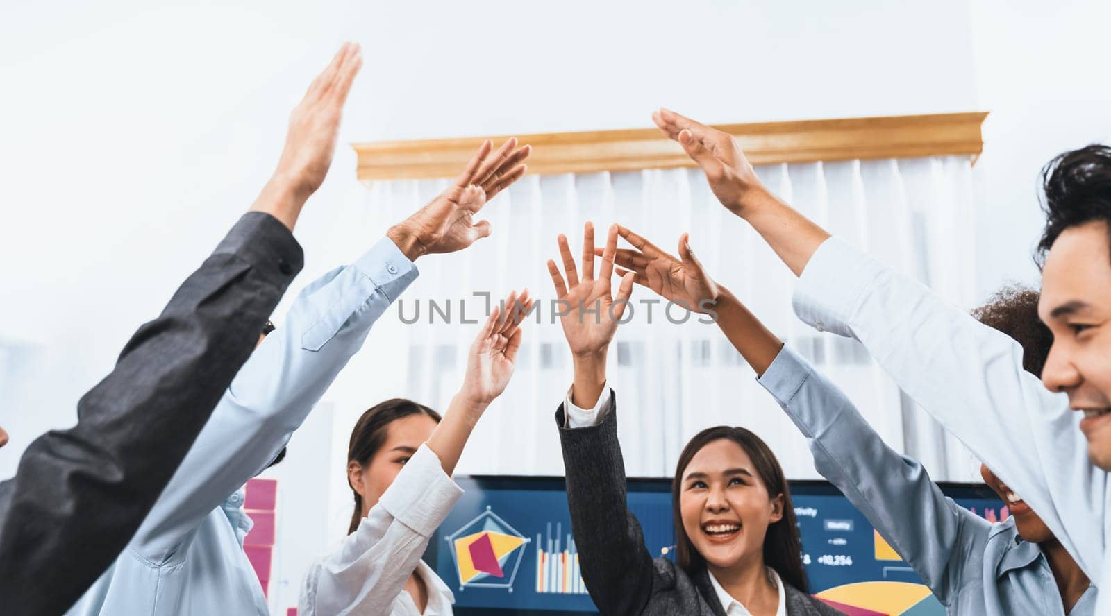 Diverse business team celebrate successful meeting with high-fives and expressions of happiness in corporate office meeting represent unity success and professional integrity. Concord