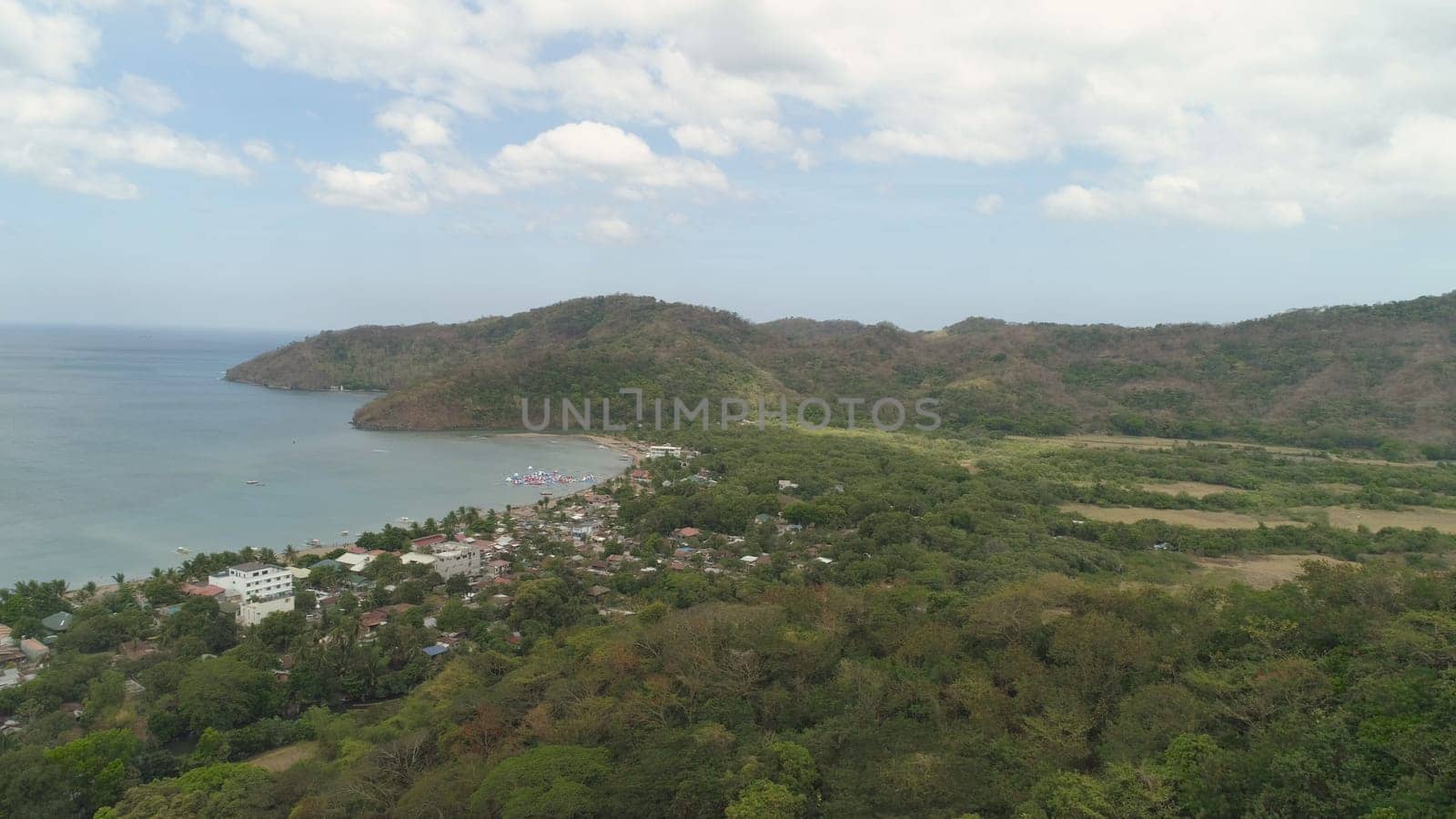 Aerial view of coast with beach in blue lagoon. Philippines, Luzon. Coast ocean with tropical beach, turquoise water. Tropical landscape in Asia.