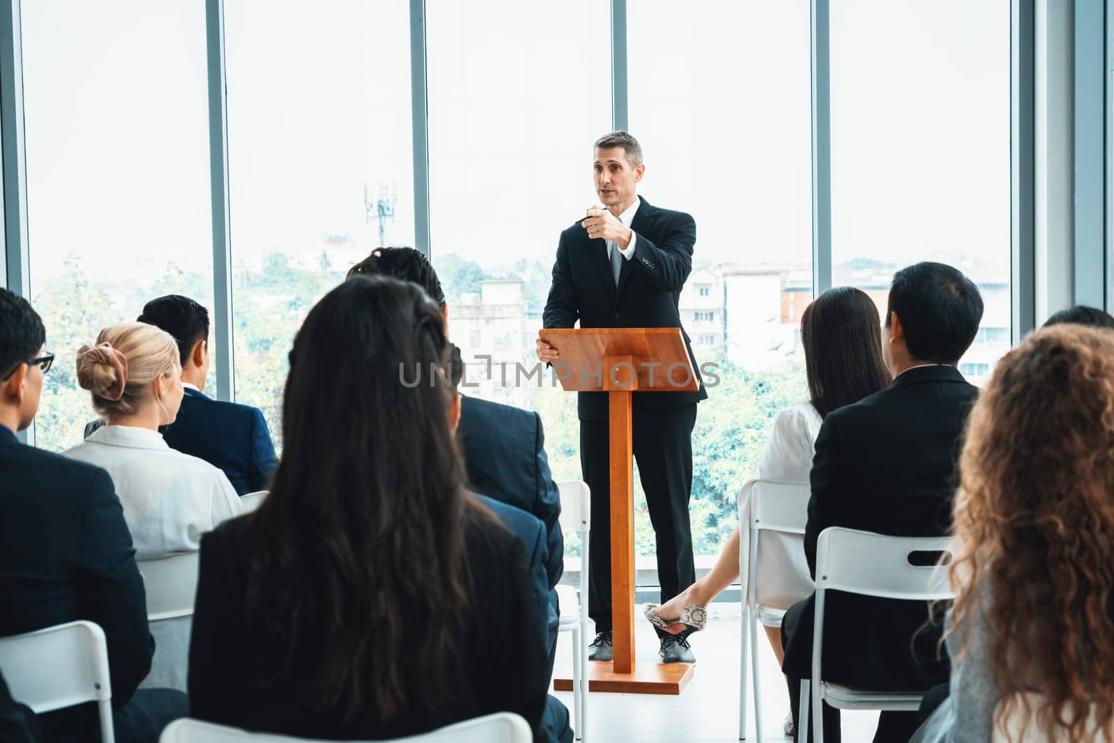 Group of business people meeting in a seminar conference . Audience listening to instructor in employee education training session . Office worker community summit forum with expert speaker . Jivy