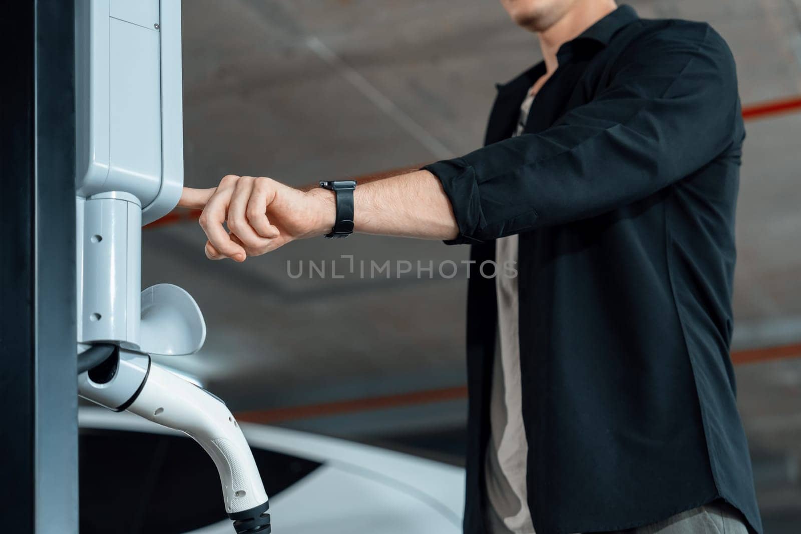 Young man travel with EV electric car to shopping center parking lot innards by biancoblue