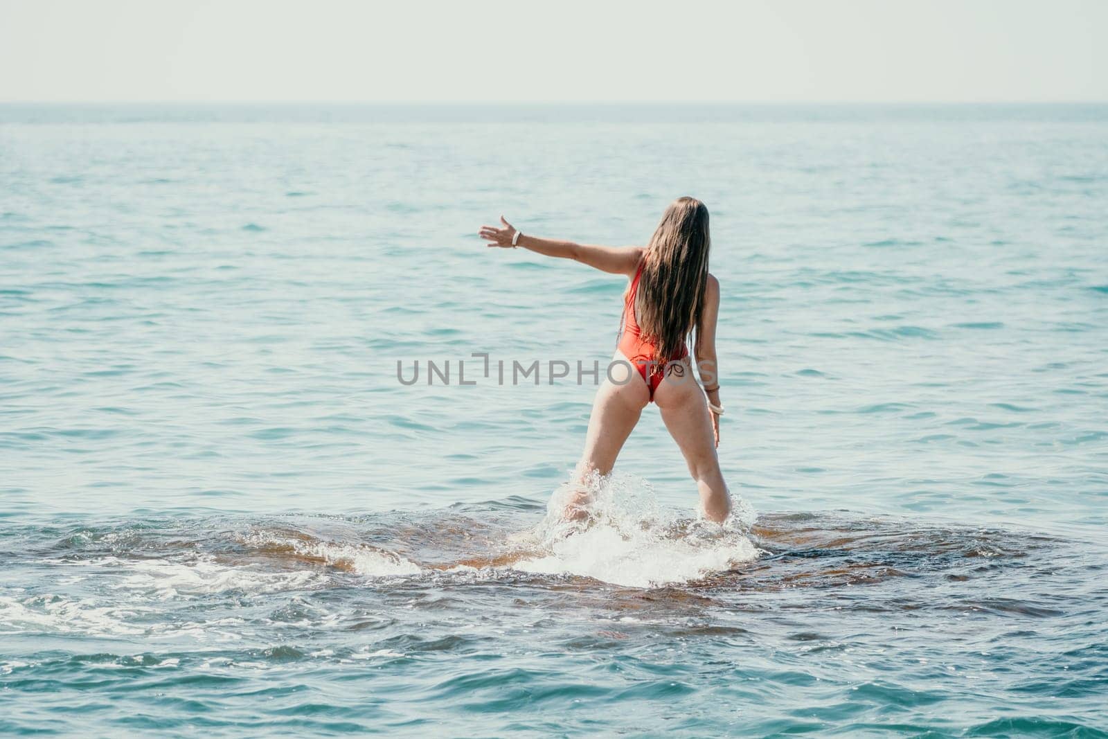 Woman sea yoga. Back view of free calm happy satisfied woman with long hair standing on top rock with yoga position against of sky by the sea. Healthy lifestyle outdoors in nature, fitness concept by panophotograph