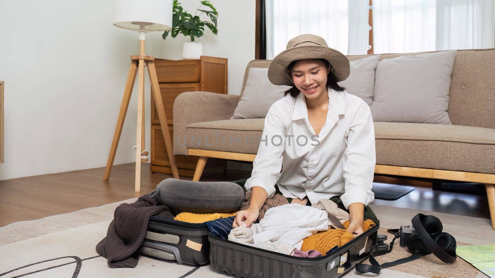 Young woman sit in floor and preparation suitcase for weekend trip. travel concept.