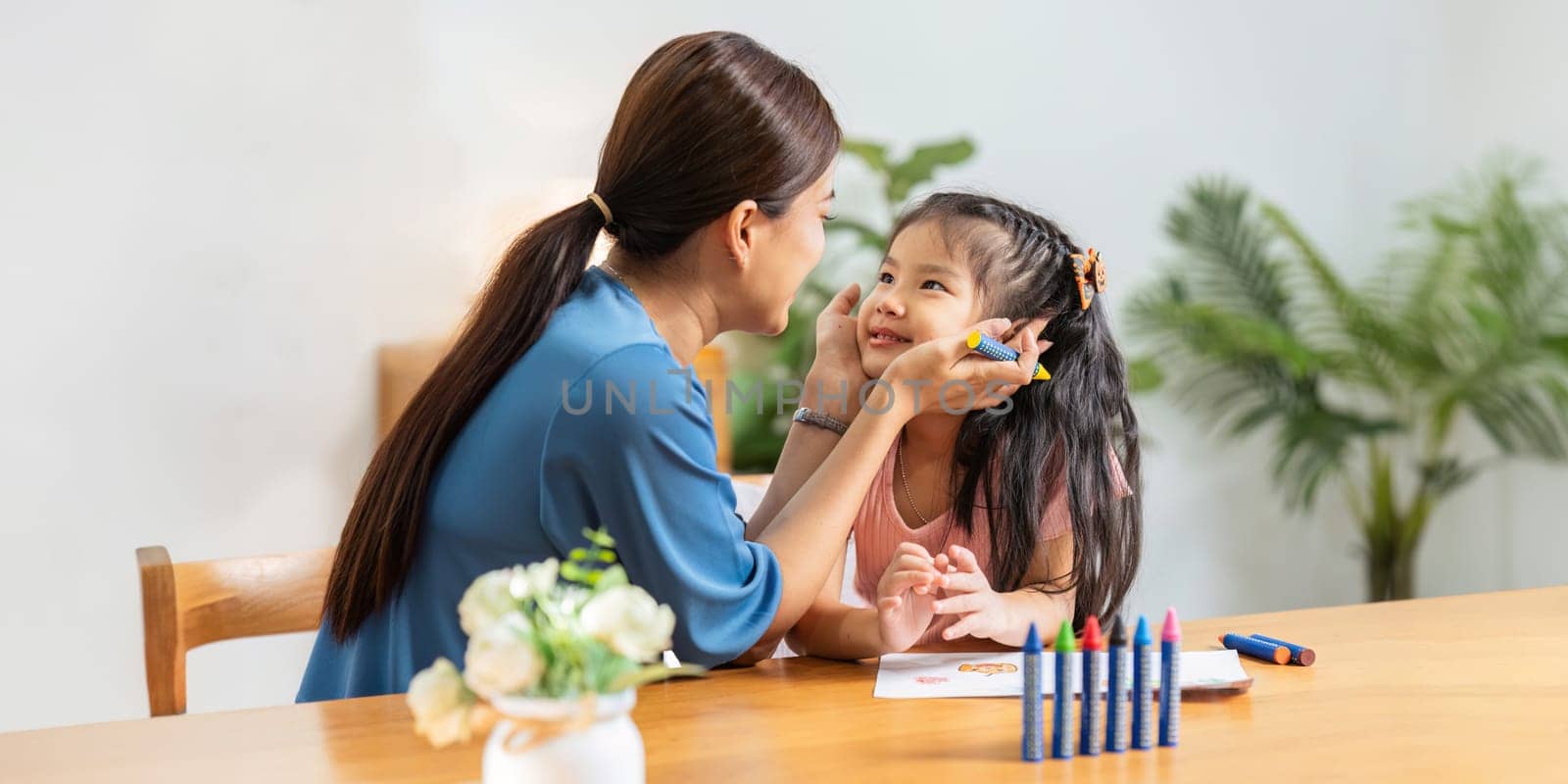 Happy family. Mother and daughter drawing together. Adult woman helping to child girl by itchaznong