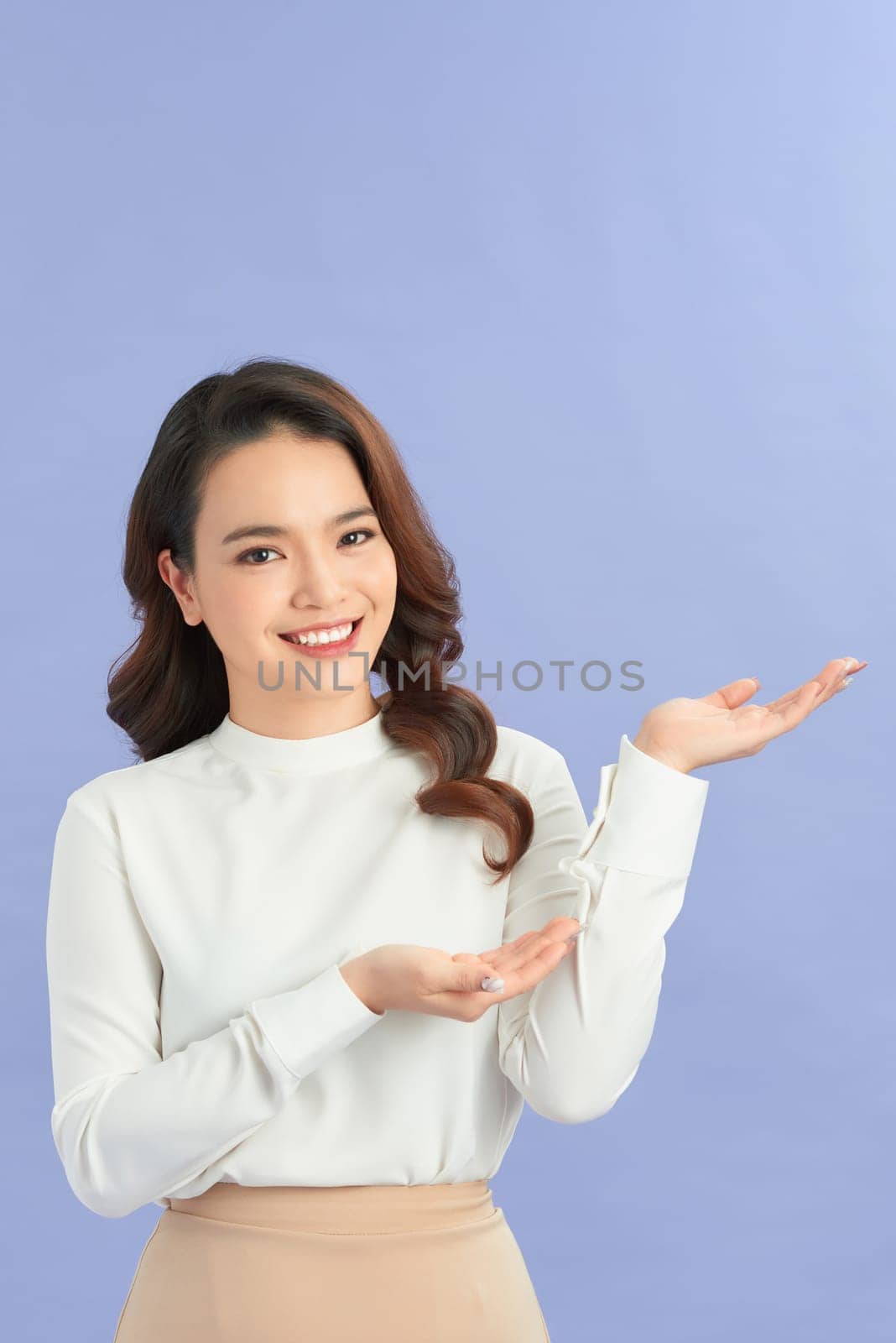 Happy smiling beautiful young woman showing copyspace or something, isolated over color background by makidotvn
