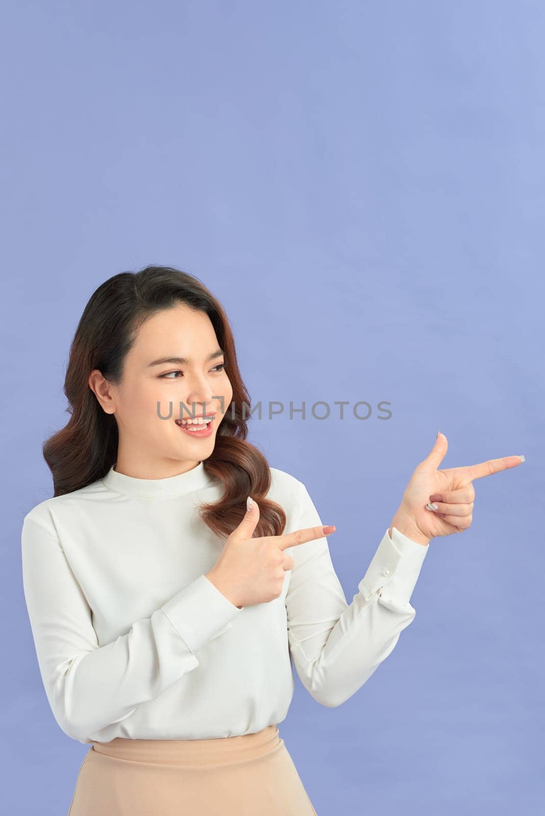 Happy Young asian woman standing while pointing something. 