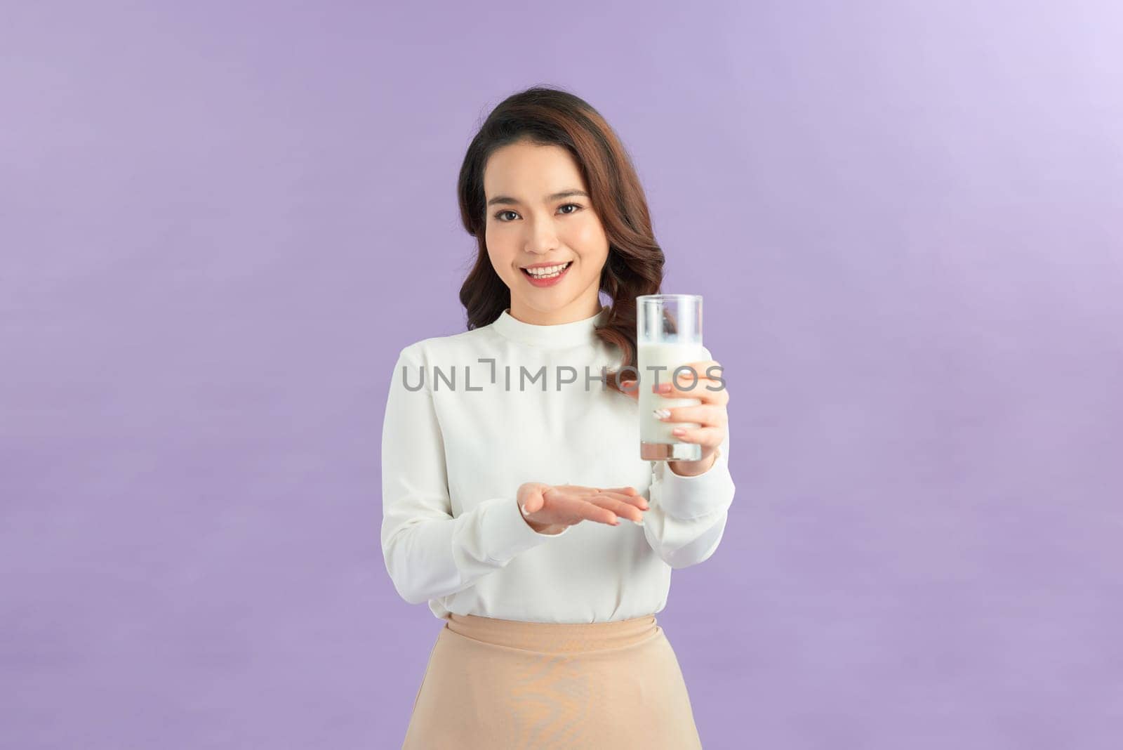 Laughing young woman with a glass of milk
