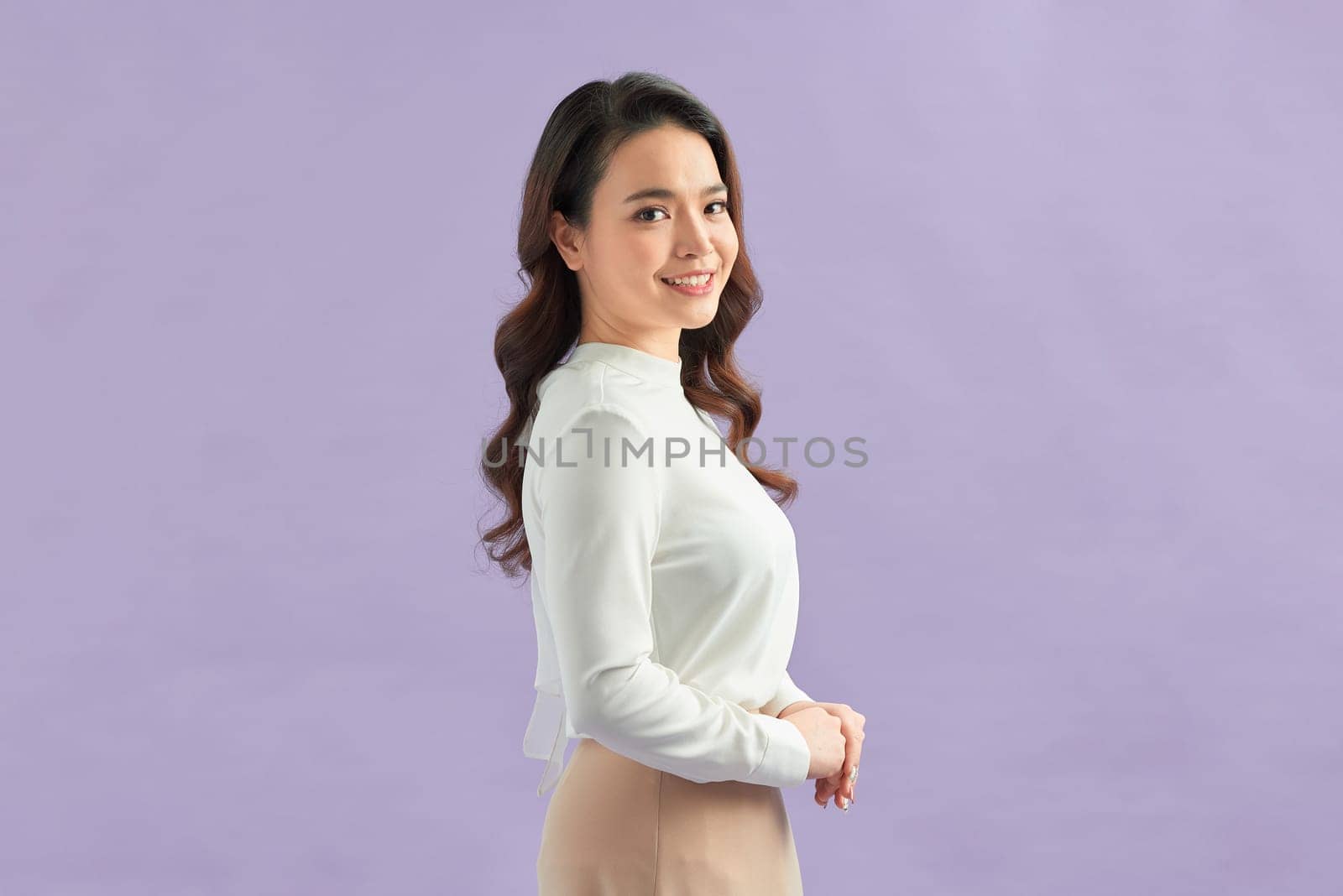 Attractive asian woman cross arms on chest and smiling confident, standing over color background