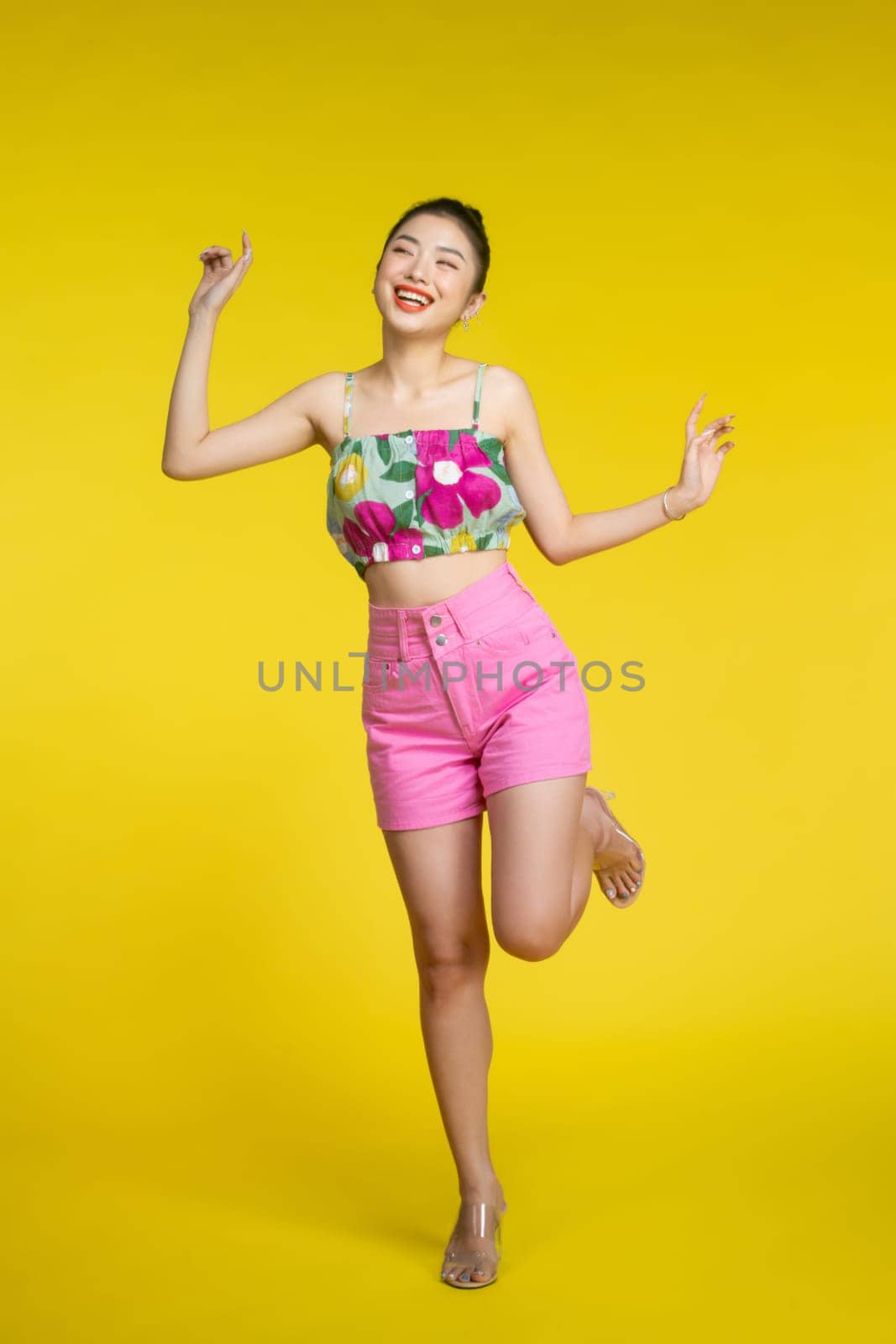 Happy, excited and woman dance, celebration and cheerful against a yellow background.