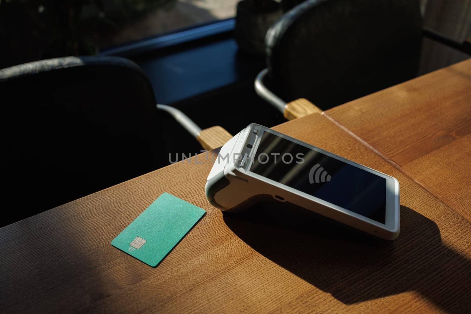 Close-up of payment terminal and credit card on table background. Paying for purchases with credit card. E-commerce. Business concept