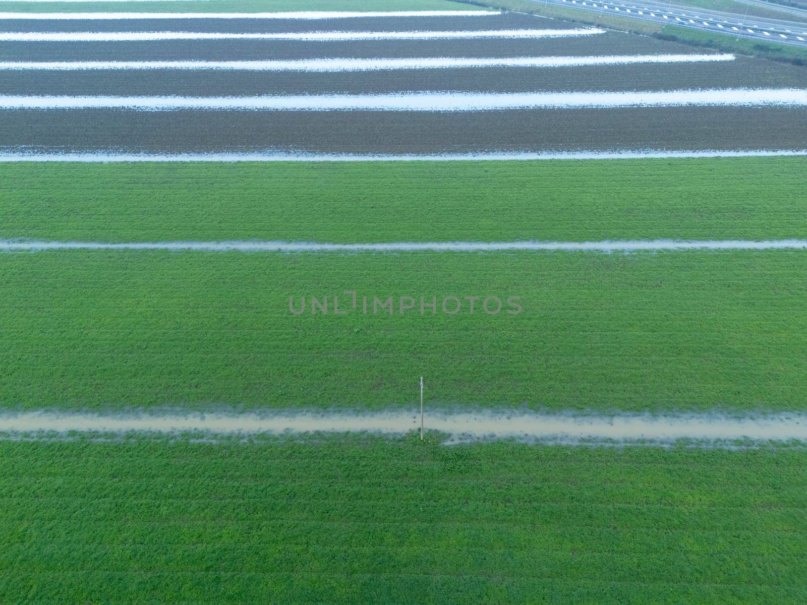 Overhead Aerial view of a flooded fields showcasing the impact of unusual heavy rainfall on rural landscapes during autumn