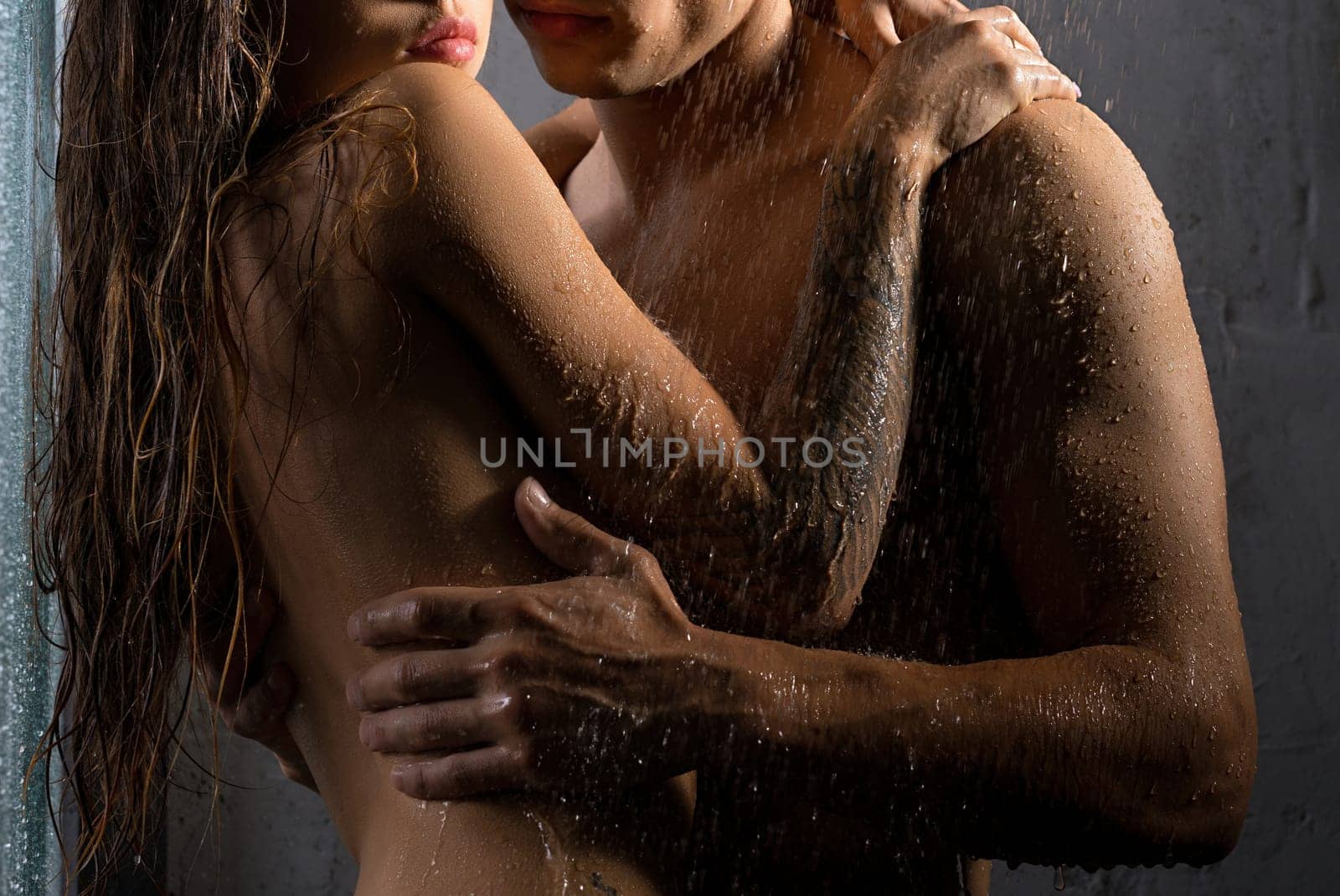 Shirtless man and girl topless embracing in shower view