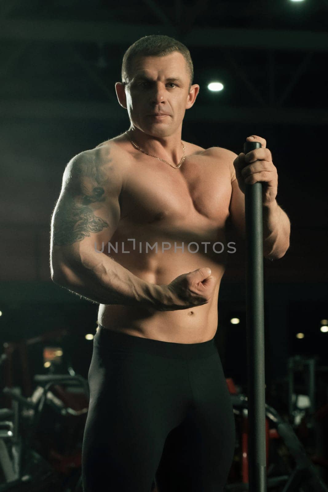 Shirtless athlete and slim fitness trainer view in sports gym