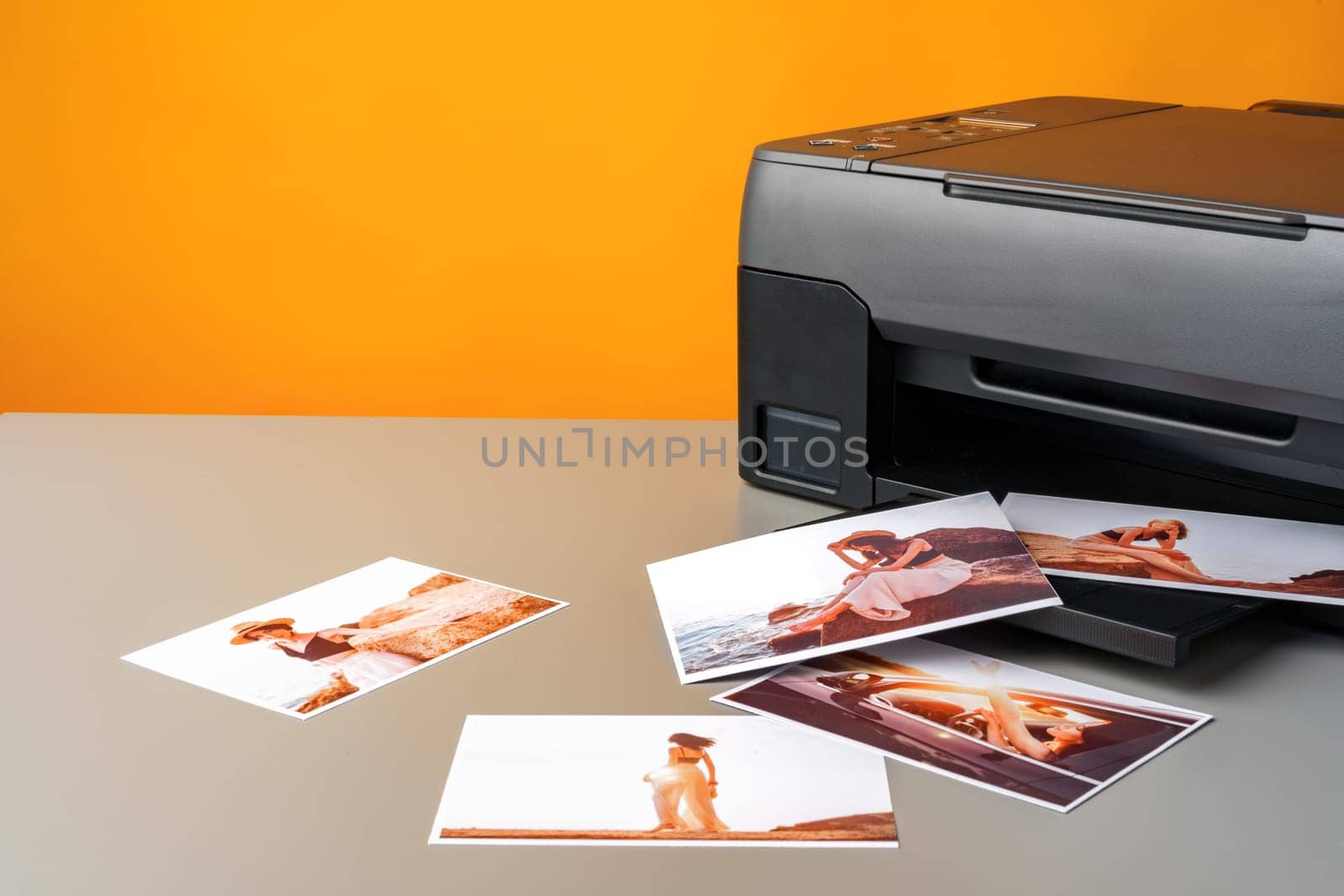 Printer printing colorful photos of people close up, yellow background, studio shot
