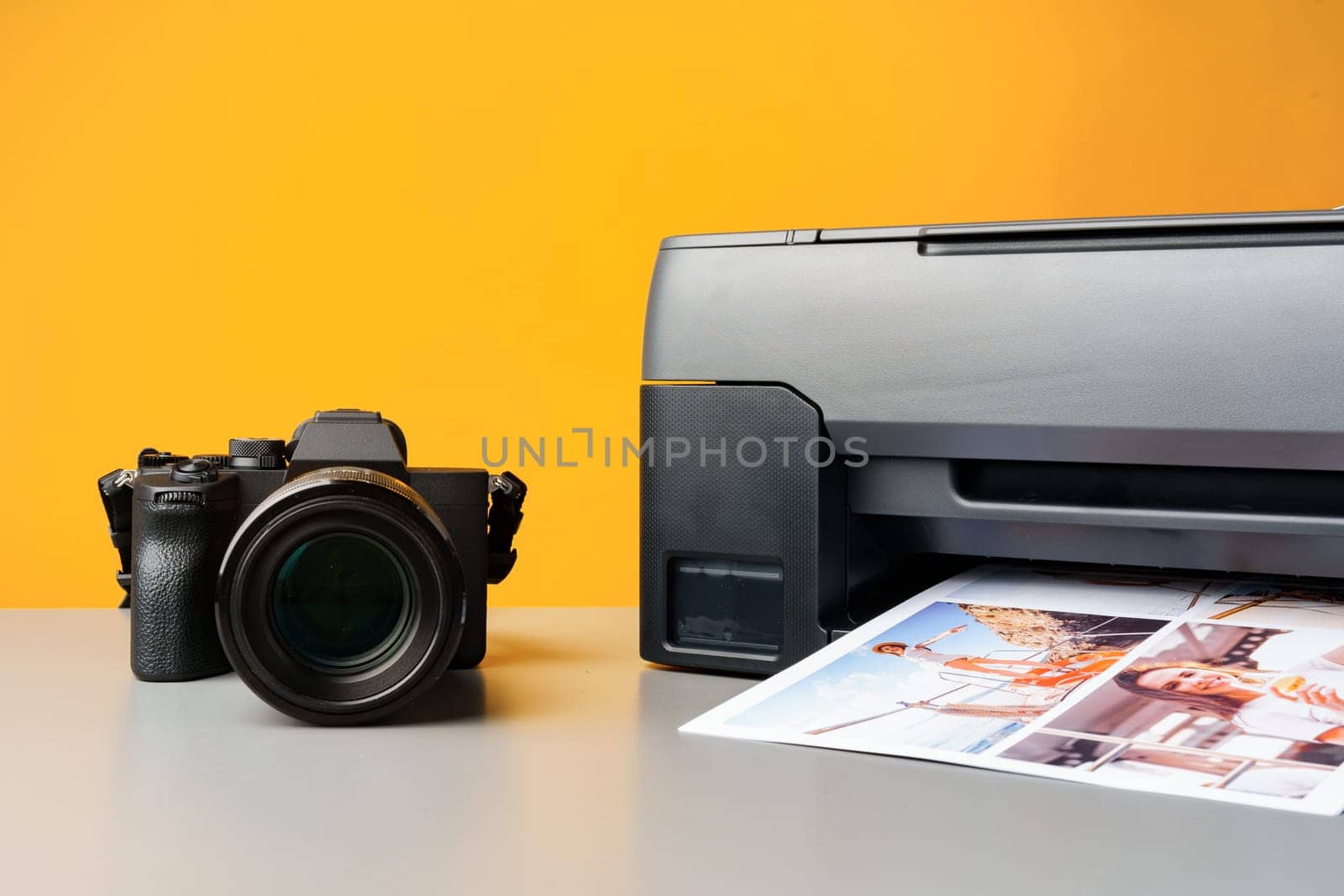 Printer printing colorful photos of people close up, yellow background, studio shot