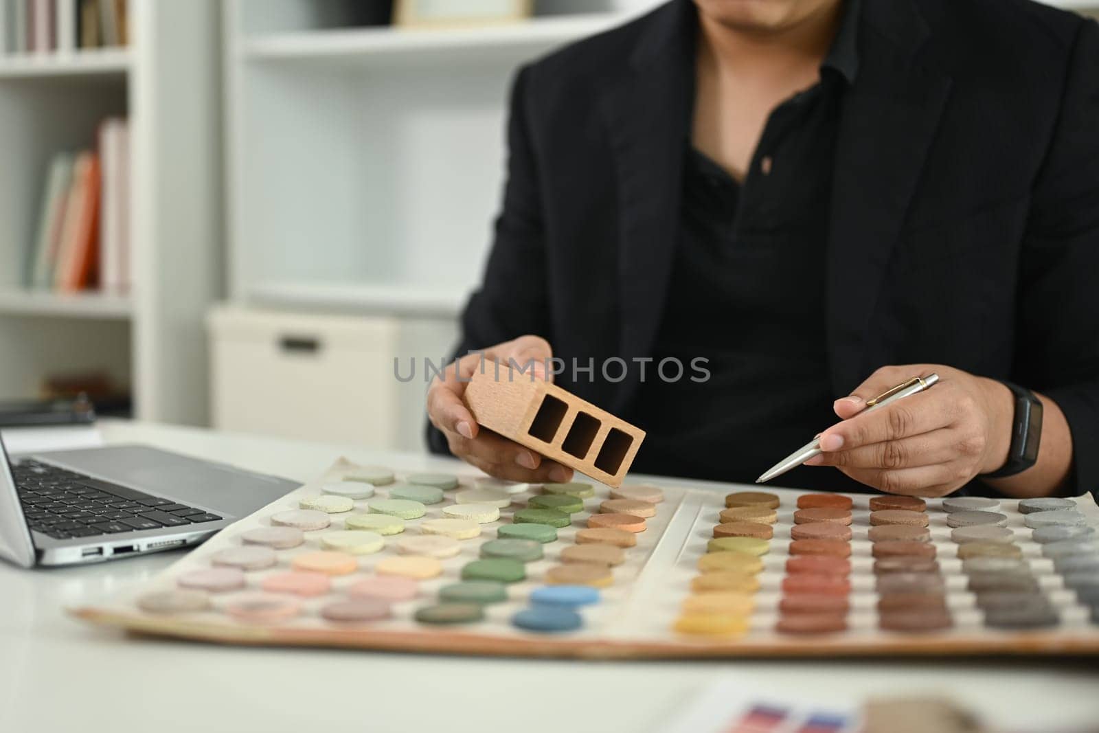 Interior designer analyzing color palettes and material samples for home project at office.