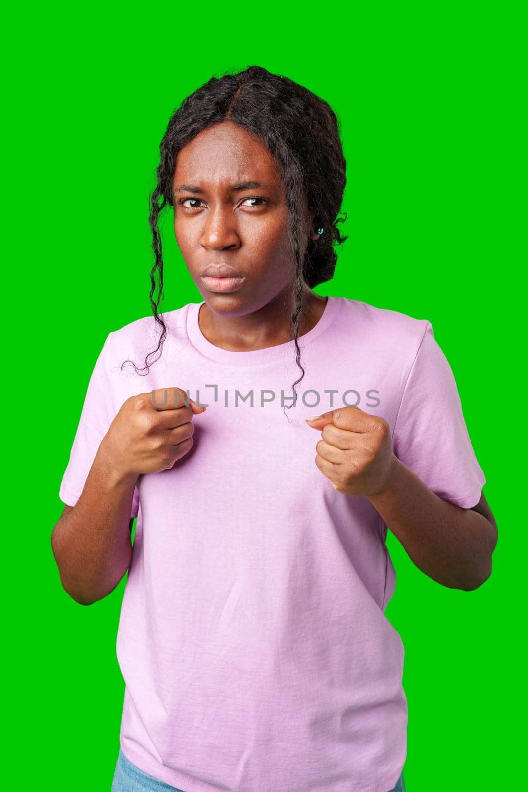 A surprised woman poses dramatically with hands on her chest in front of a bright green background in studio