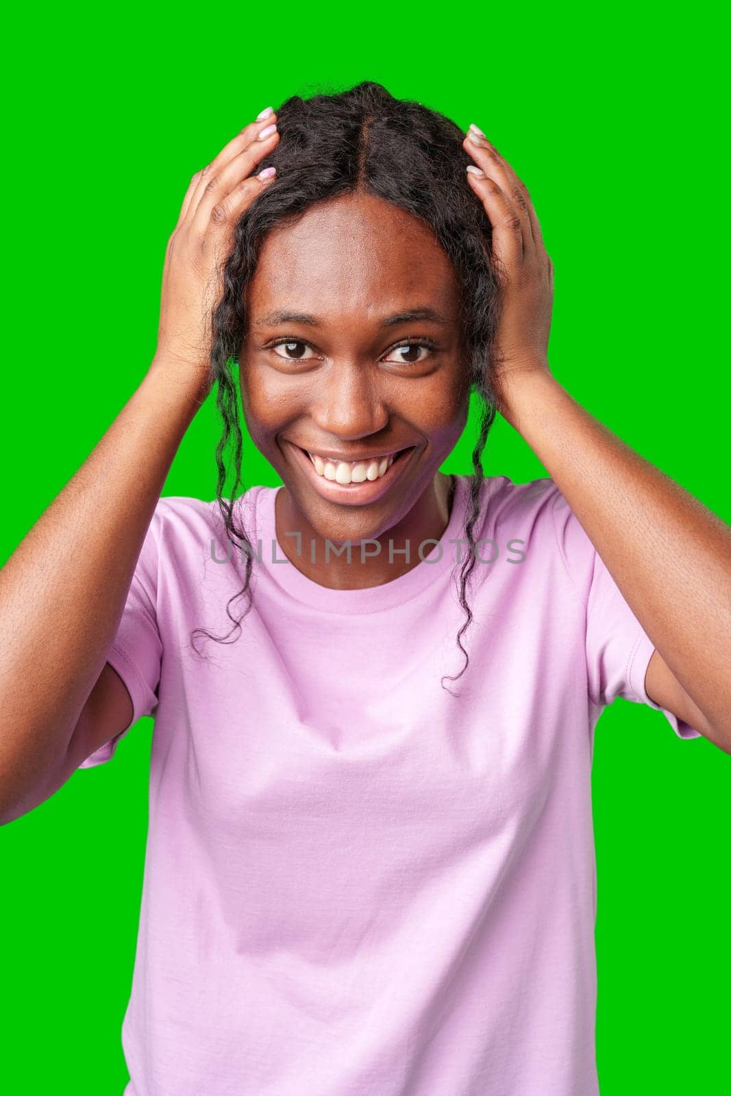 Woman expressing surprise and excitement on a bright green background in studio