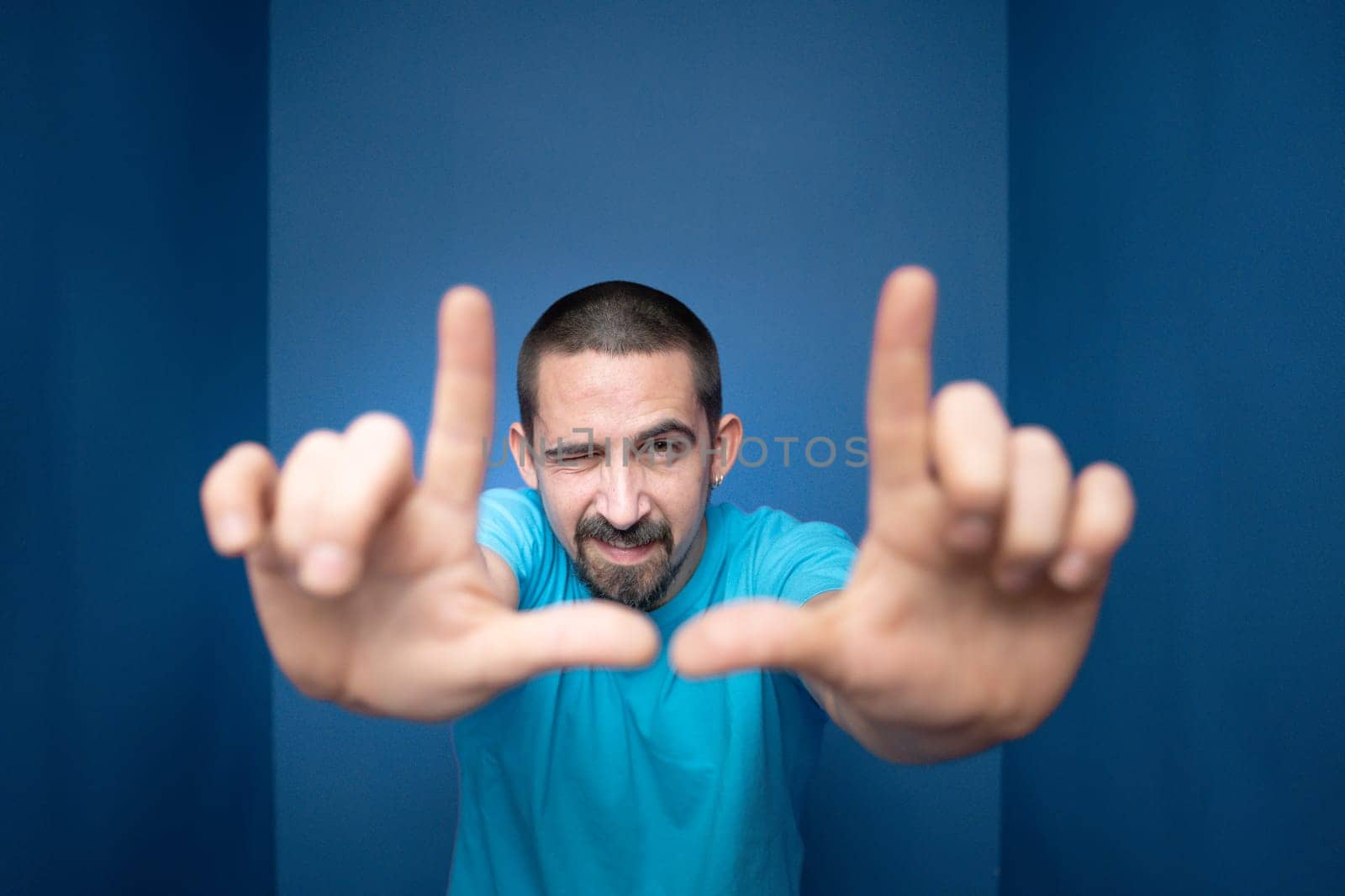 Young man doing frame using hands and fingers, isolated over purple background. High quality photo