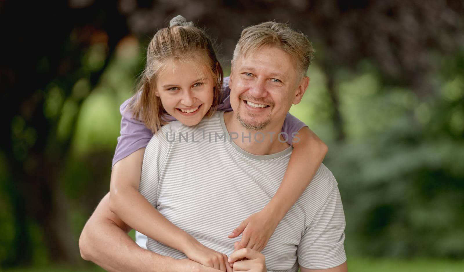 Father And Daughter Posing In A Park During Summer