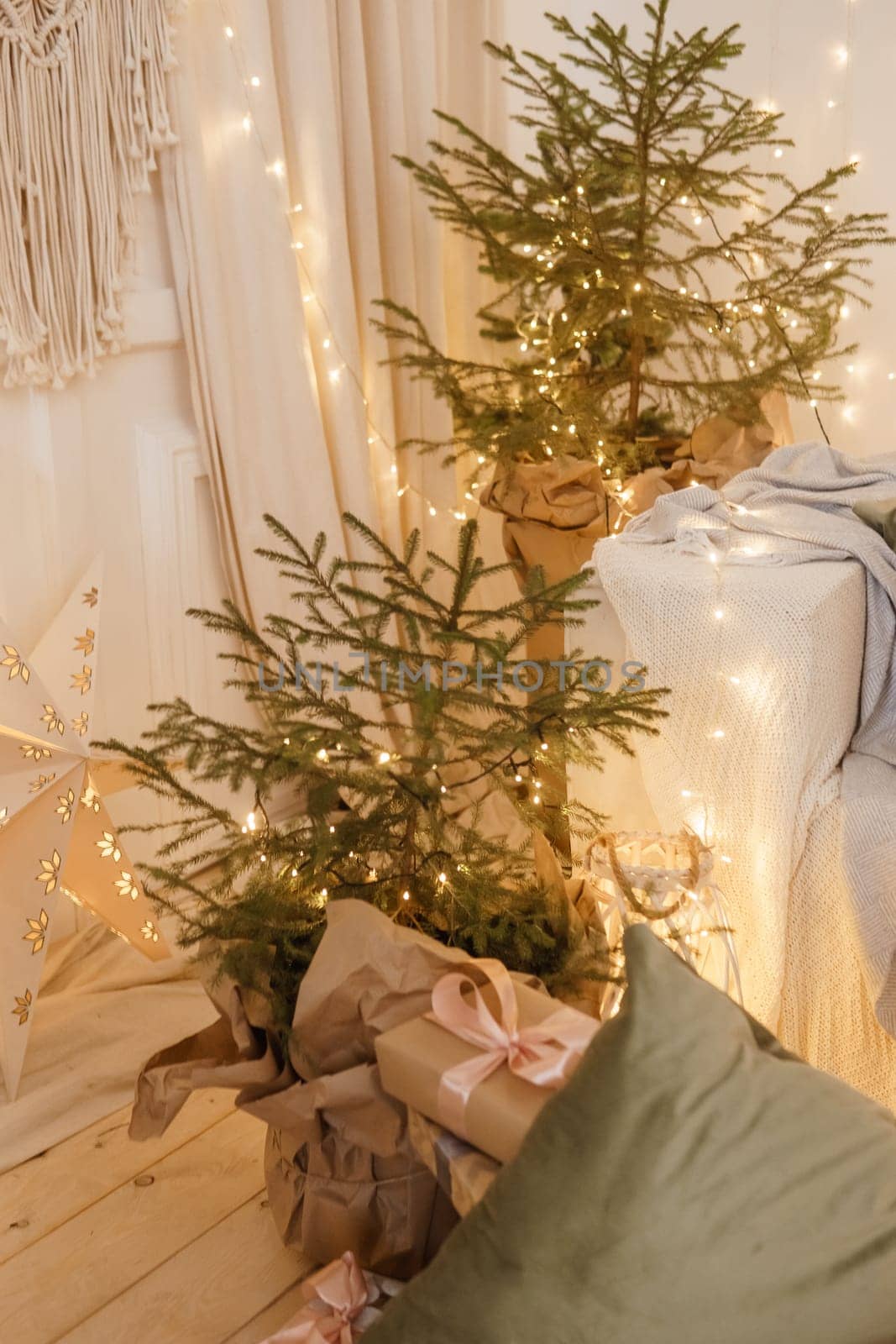 Designer Christmas tree decoration with light decorations. The concept of celebrating New Year and Christmas. Gifts in craft packaging under the Christmas tree.