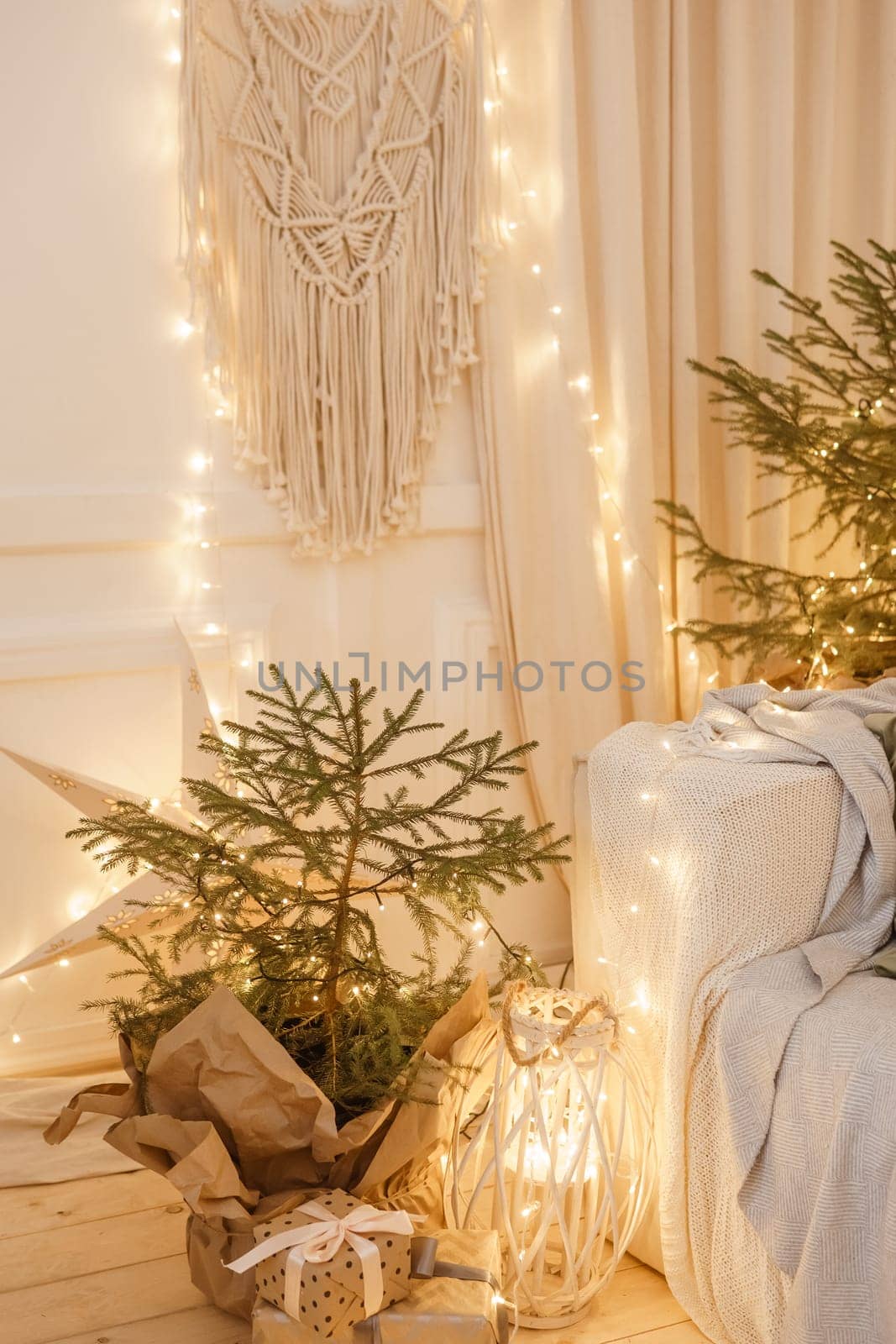 Designer Christmas tree decoration with light decorations. The concept of celebrating New Year and Christmas. Gifts in craft packaging under the Christmas tree.