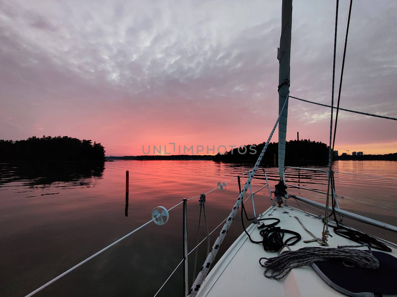 View from the bow of a sailing yacht on a beautiful red sunset in the Baltic sea