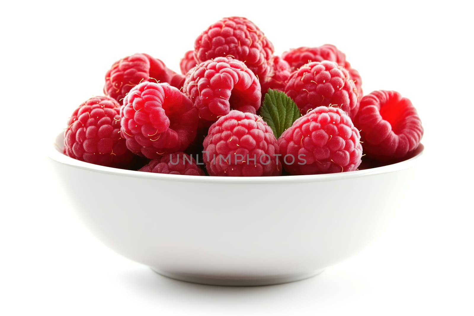 A white bowl is filled to the brim with fresh, vibrant raspberries, showcasing their rich color, with a green mint leaf adding a refreshing touch.