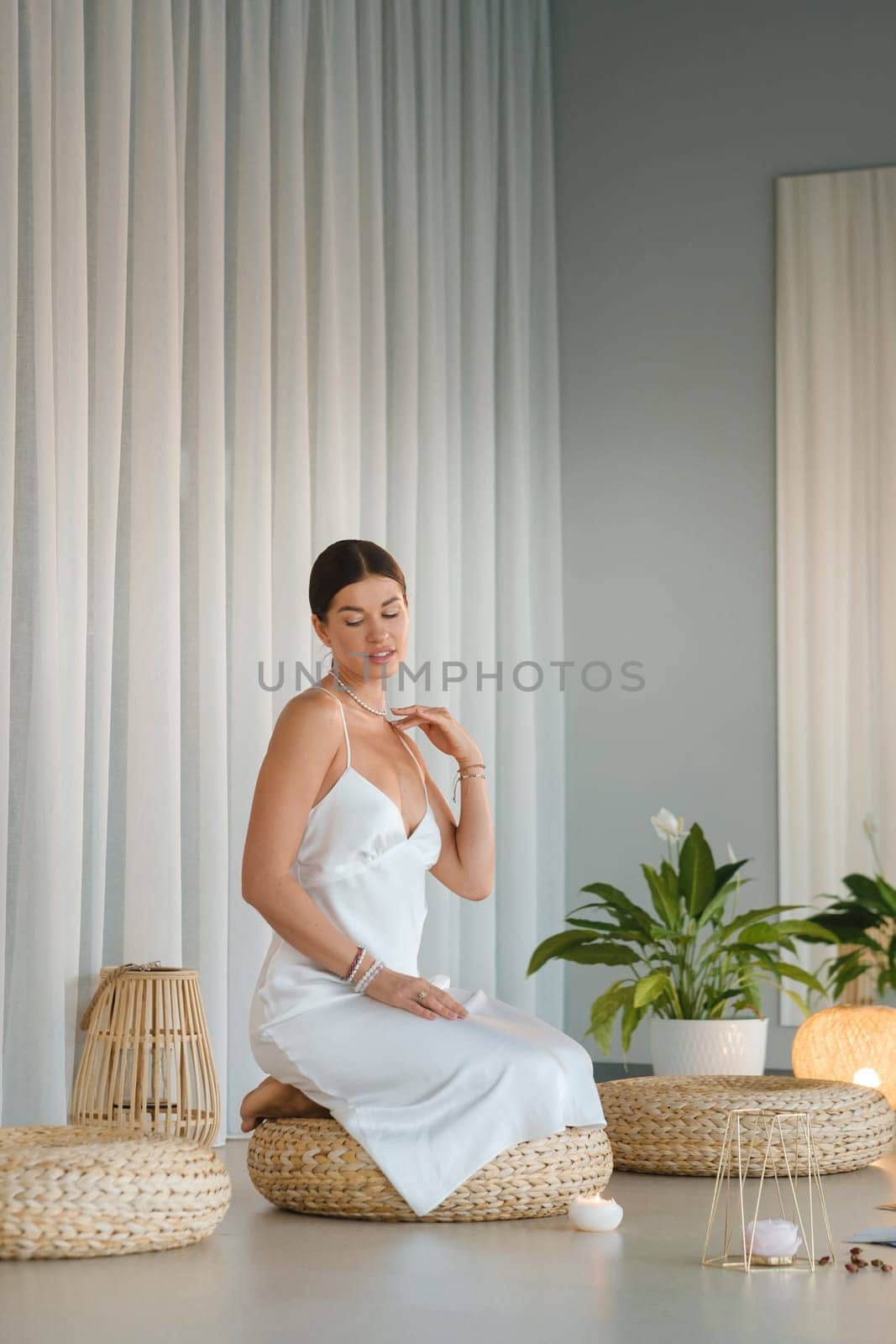 Girl in white dress does aesthetic gymnastics in gym. Girl doing yoga in the gym.