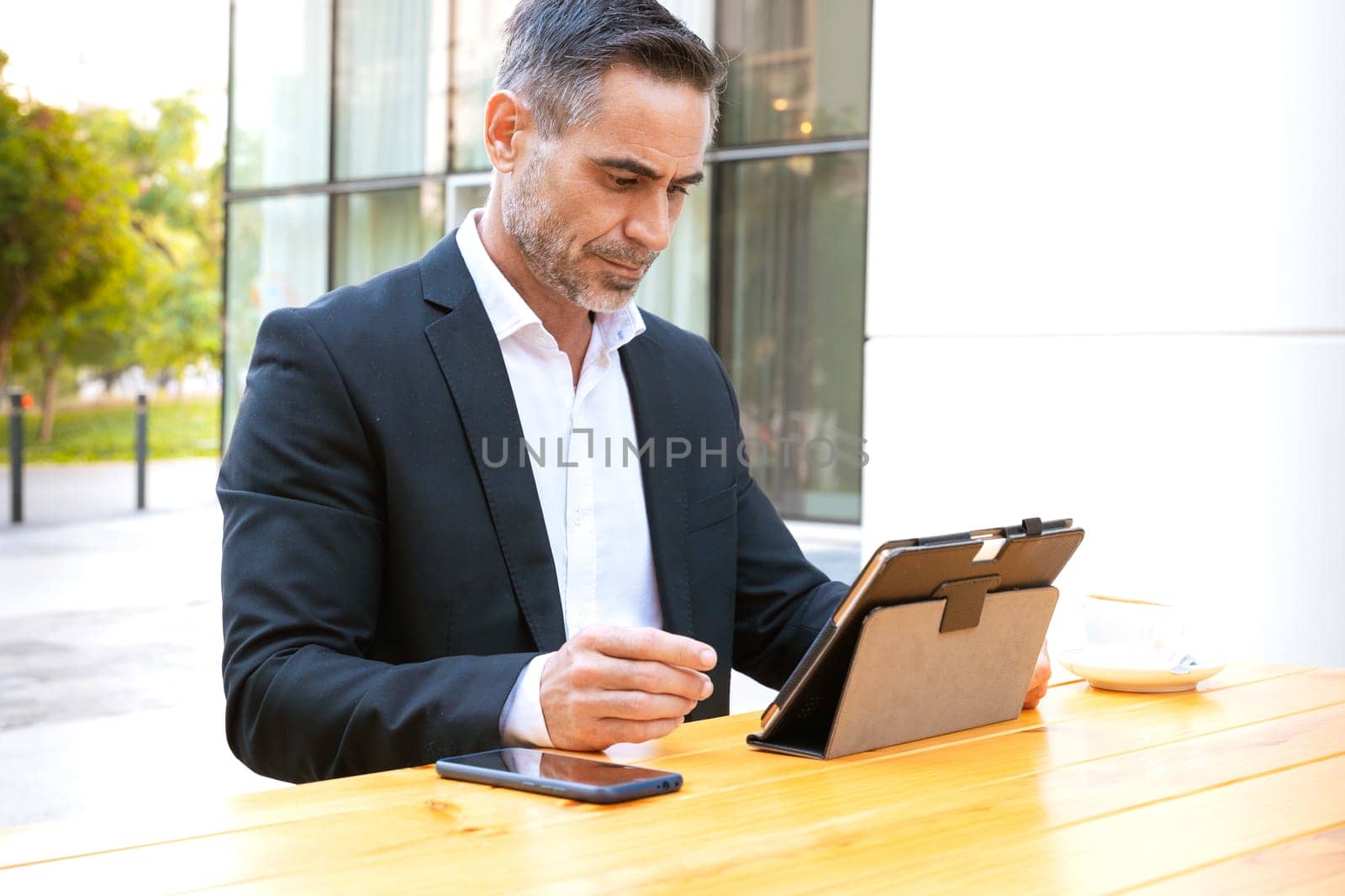 Business on the move: Businessman working on his digital tablet on the street. Man Hands Type On His Laptop Outdoors
