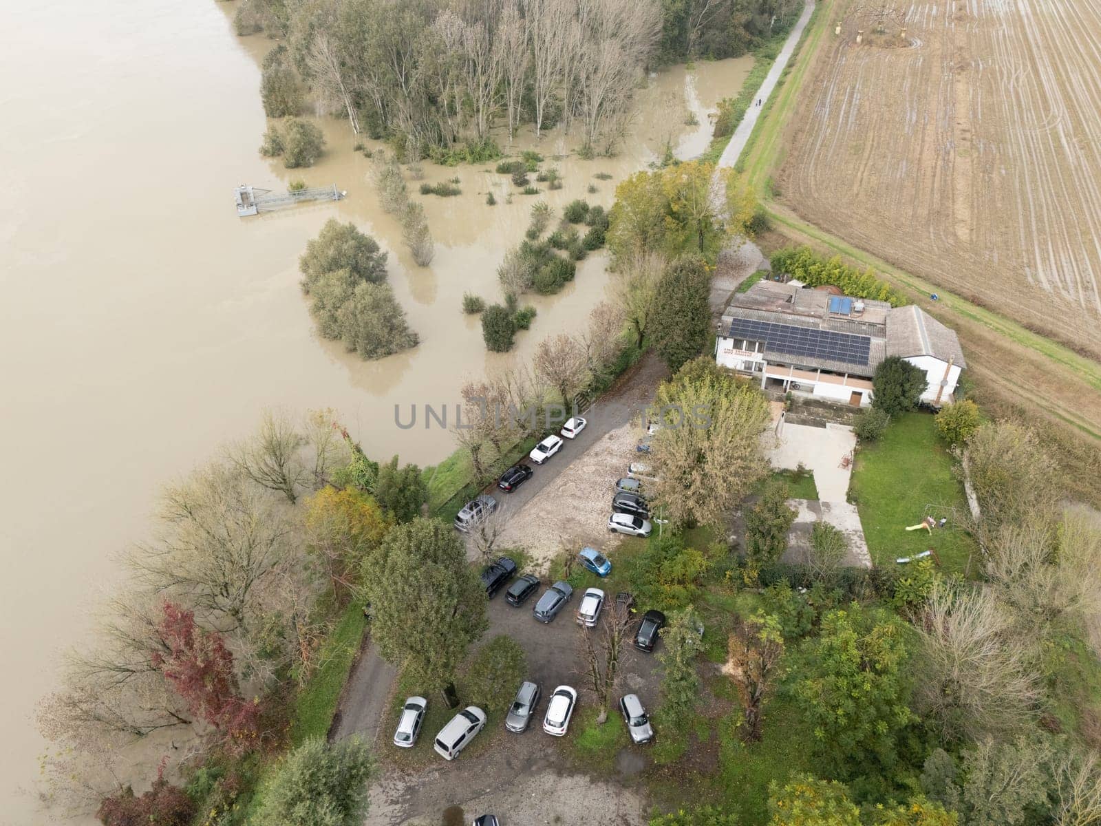 Stagno Lombardo, Italy - October 20th 2024 Aerial view of river overflooded rural area after heavy rains, muddy water covering fields, reaching doorsteps of trattoria Lido Sales