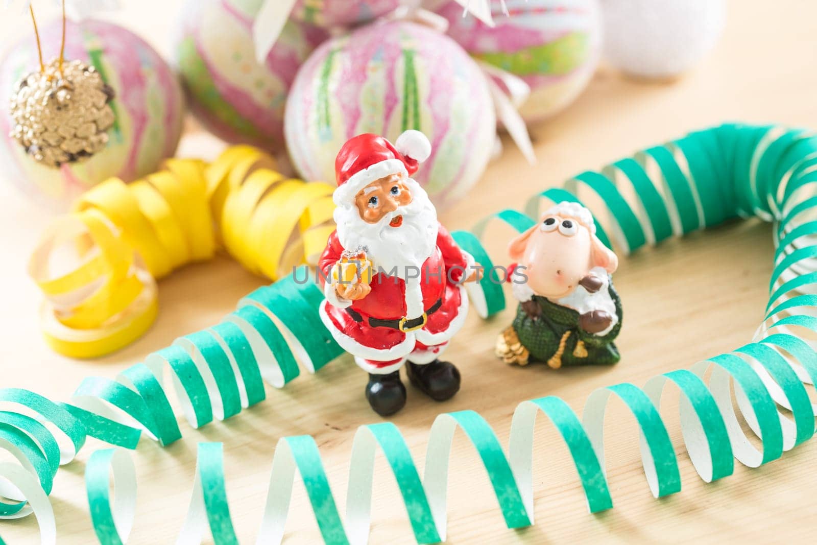 A small figurine of Santa Claus in a red and white suit holding a green sack.