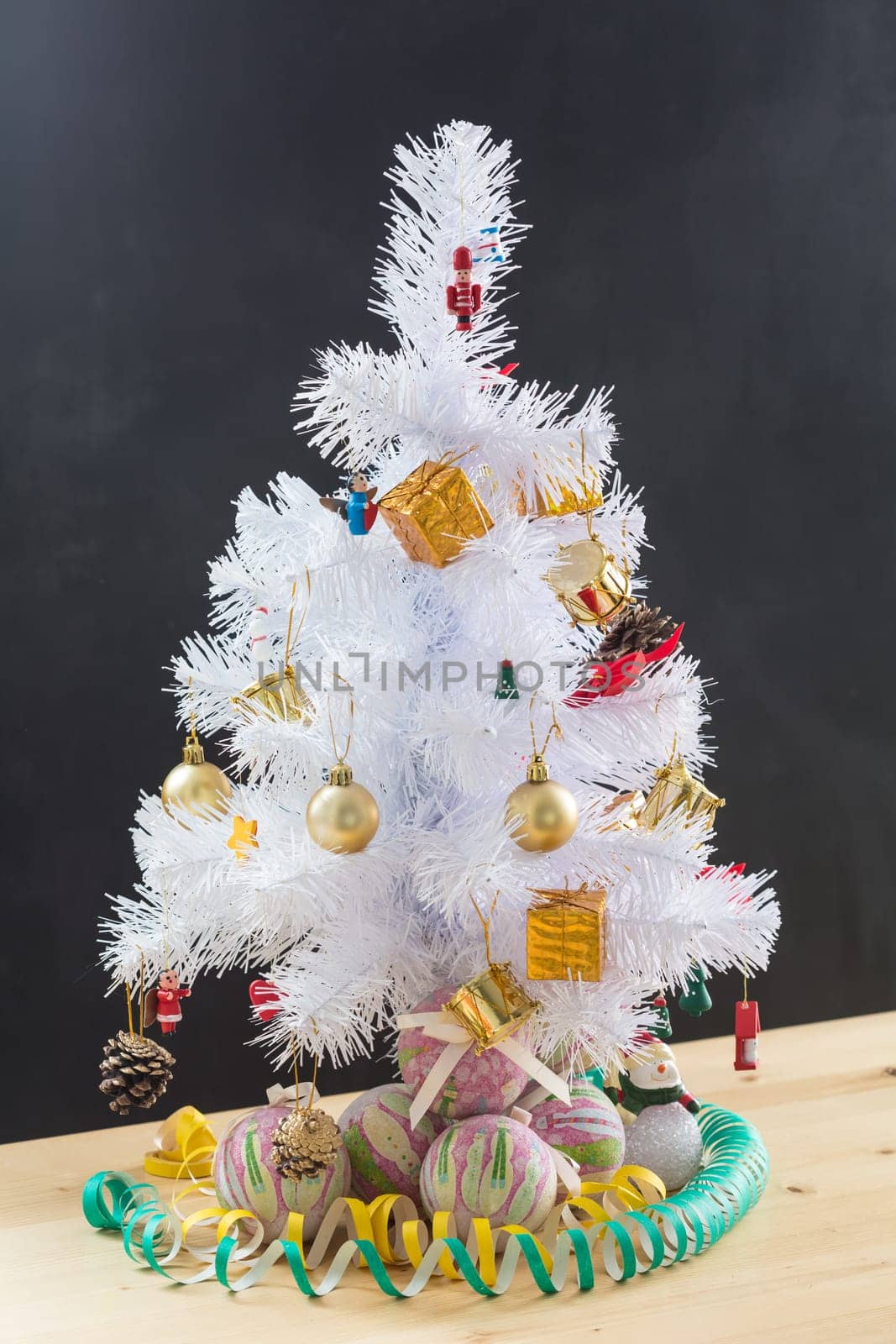 Small Christmas tree sitting on top of stool in a minimal room