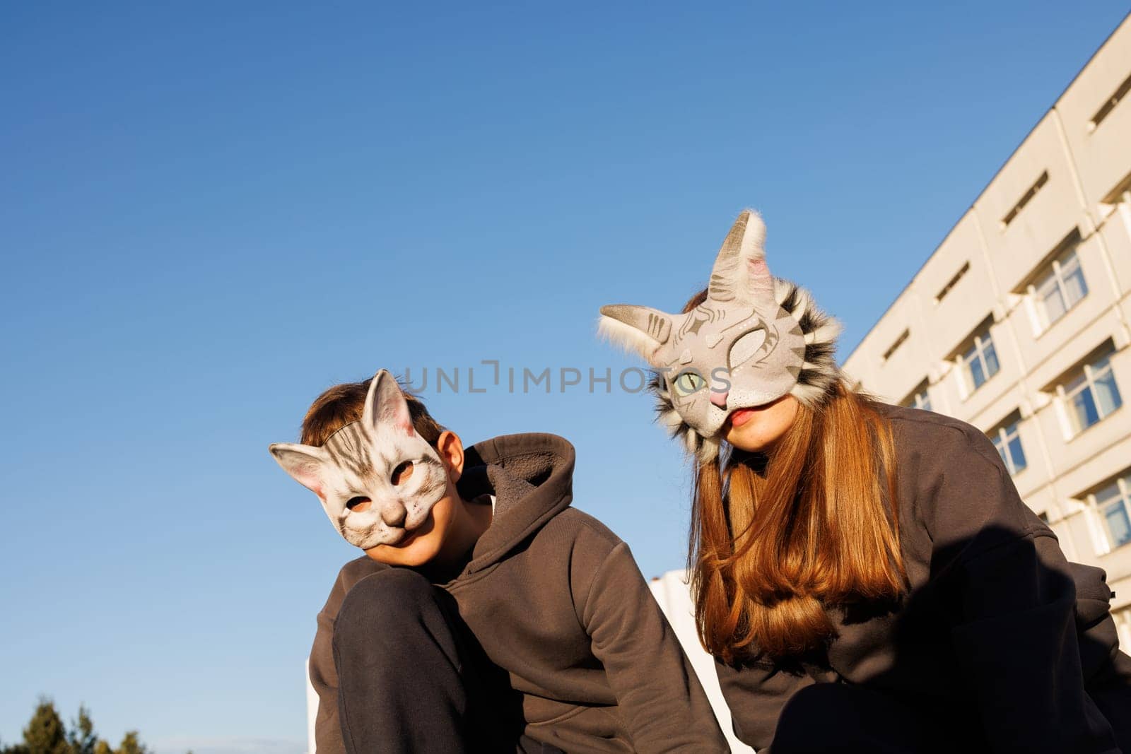 girl and boy in cat masks and cat costumes doing Quadrobics in the city, animal behavior simulation, Quadrobics sport