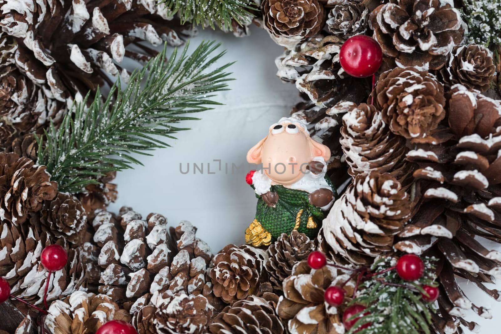 Elegant christmas wreath decorated pine cones and fir trees on white light grey wooden door. Christmas mood. Beautiful vintage door. Christmas mood: festive christmasy themed winter natural wreath on