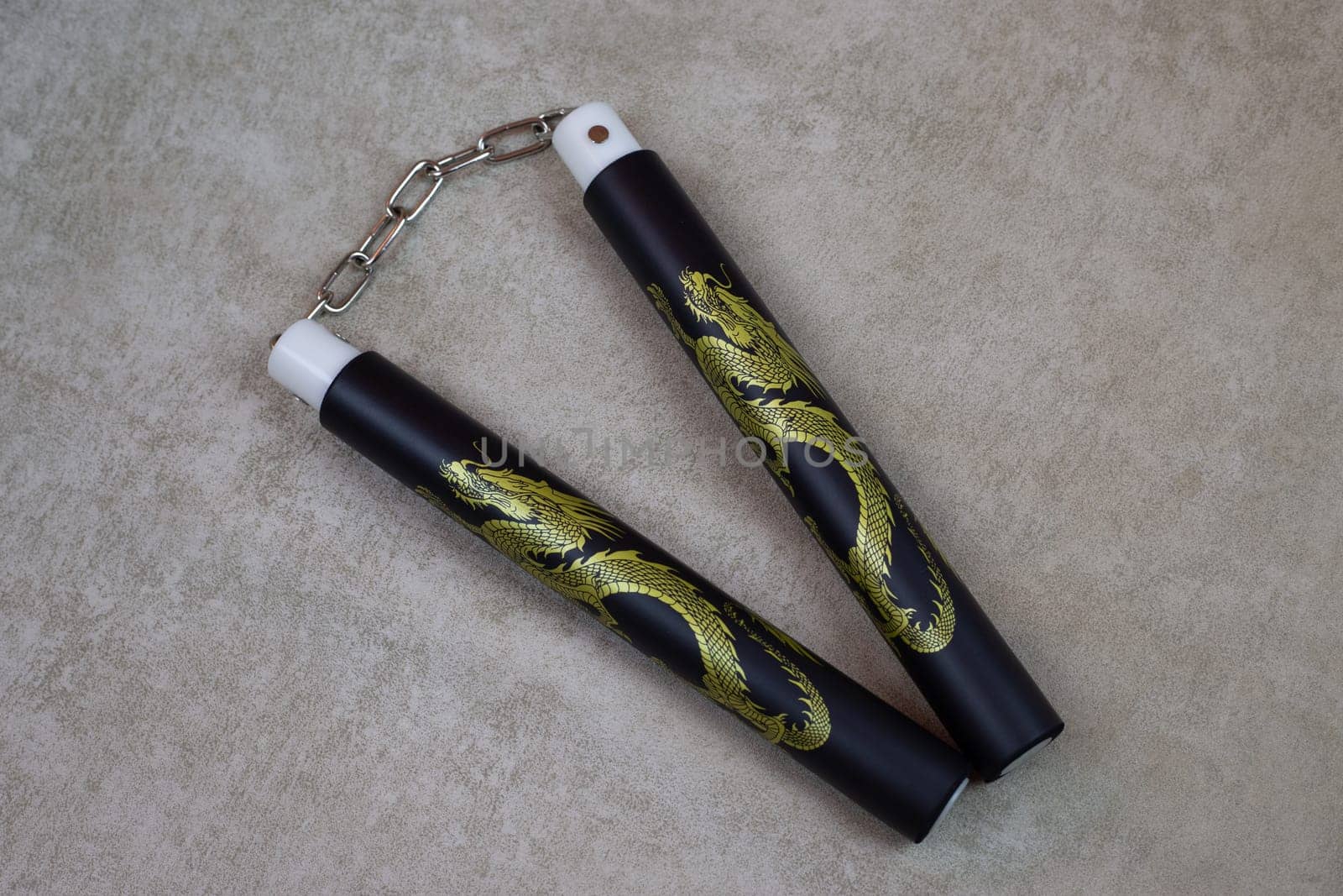 Black nunchucks with golden dragon for martial arts training, special ancient weapons for self defense. Body agility training with soft material nunchuck, martial arts culture using weapons