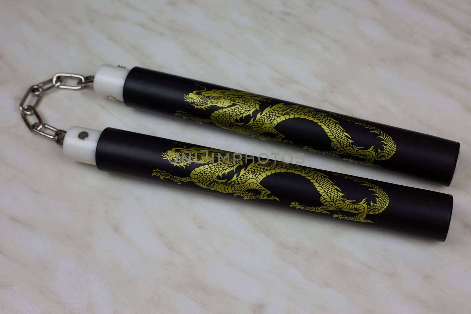 Training nunchucks made of soft material on white background, oriental inertial edged weapons of impact, shock-crushing and suffocating action, foam rubber training nunchucks