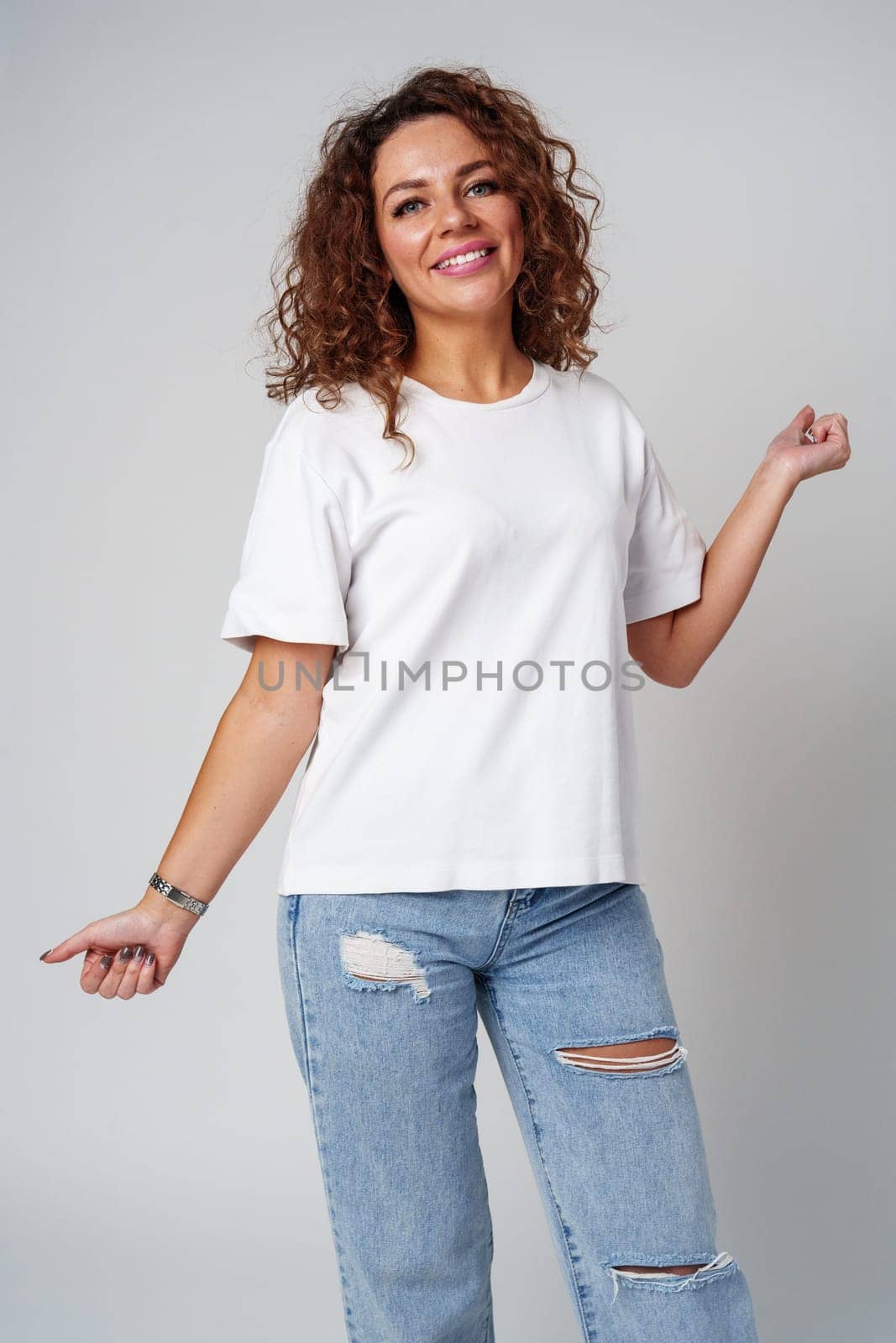 Young woman joyfully celebrates in casual attire against a neutral background close up