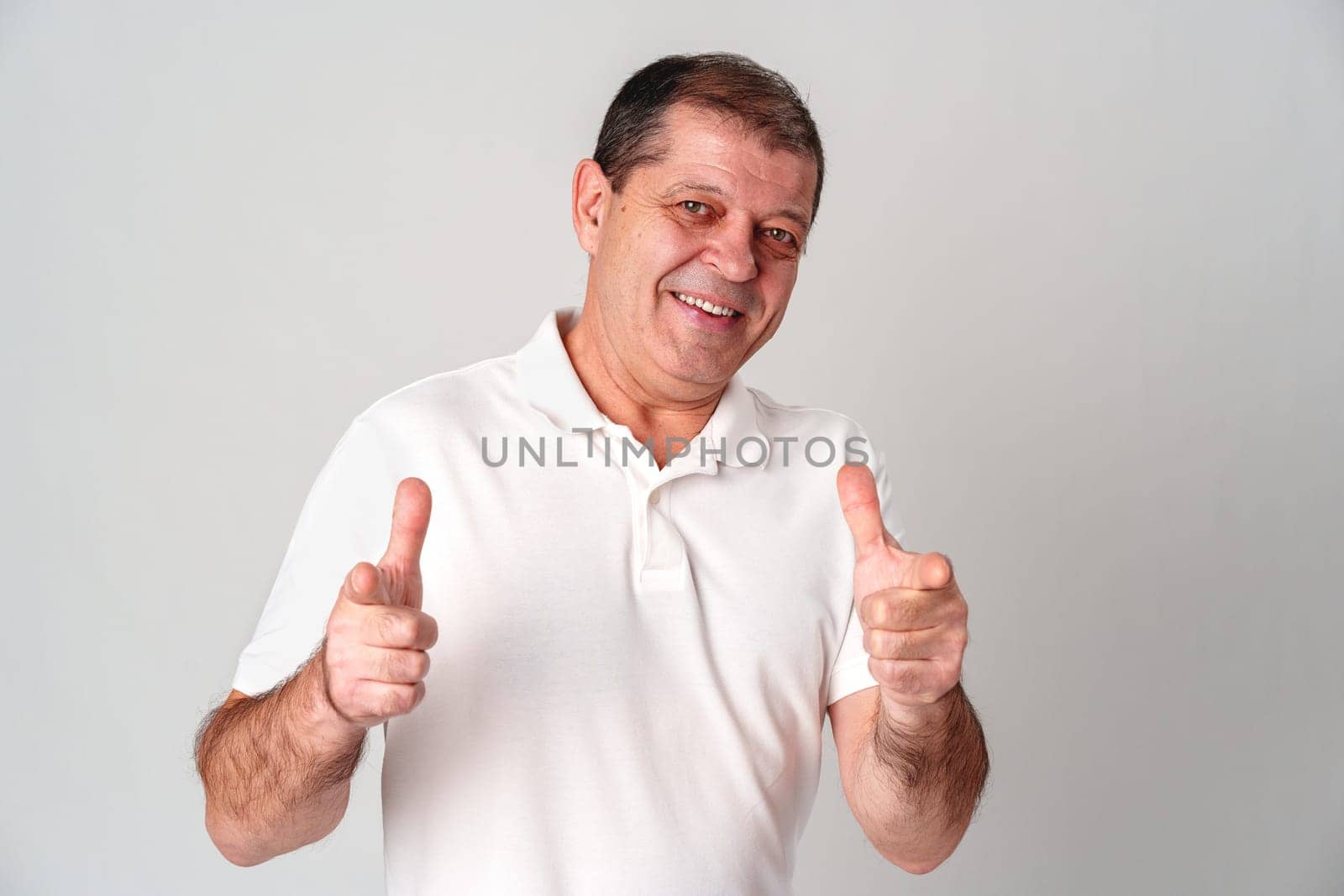 An older man smiling and reaching out with both hands in studio