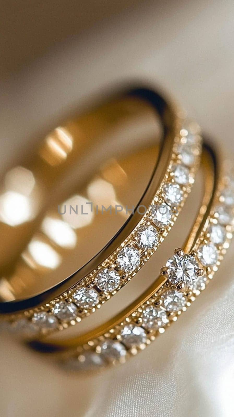 Two simple gold wedding rings are laying on white cloth, ready for the couple to exchange during their wedding ceremony