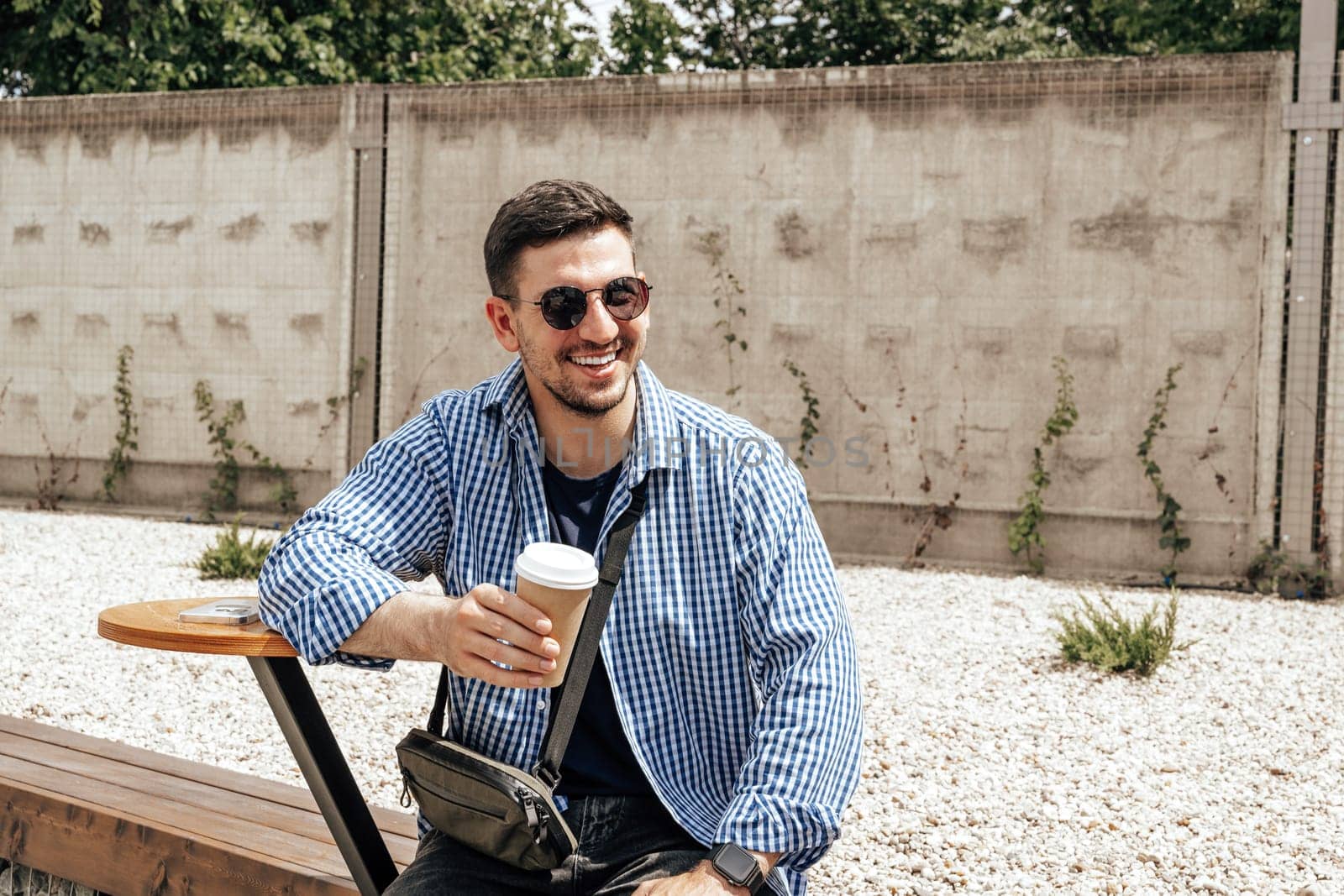 Cheerful man enjoying coffee at an outdoor cafe close up