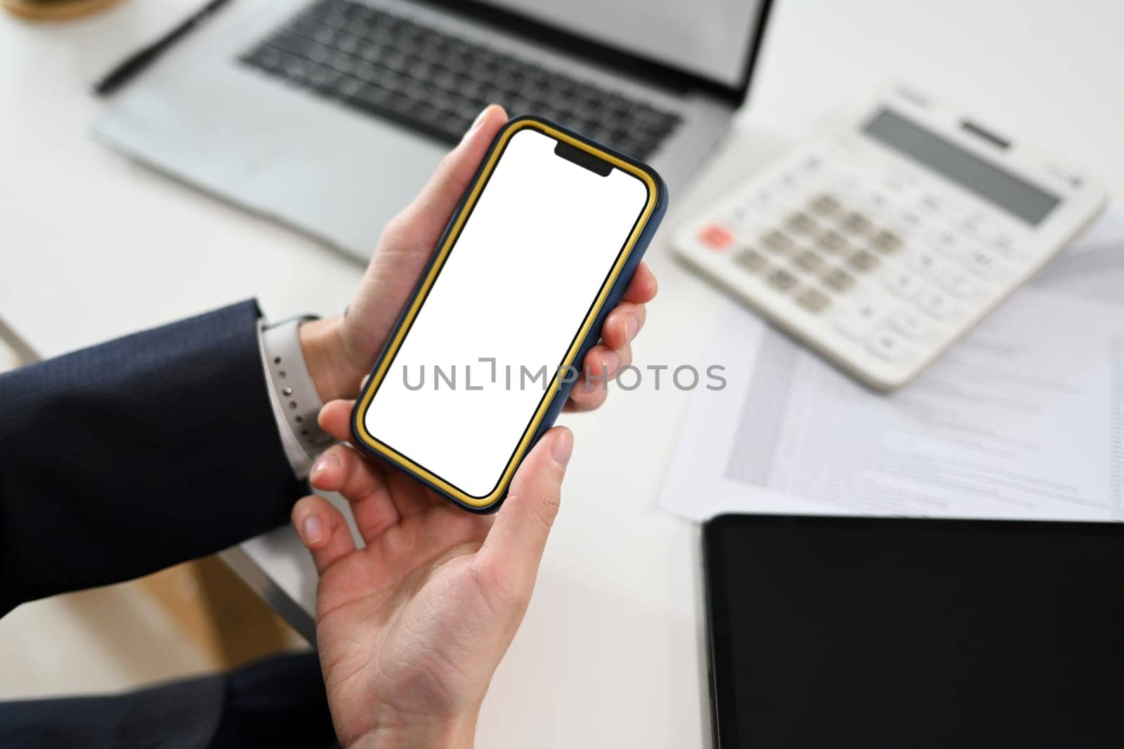 Close up shot of businessman holding mobile phone with white empty display.