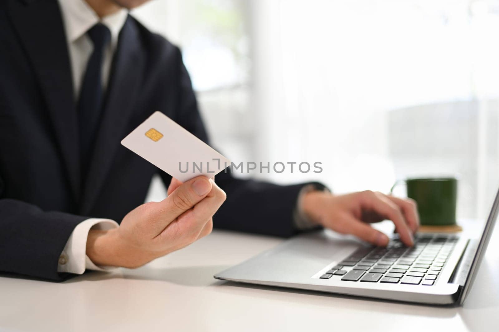 Cropped shot of businessman making a purchase or payment with credit card online.